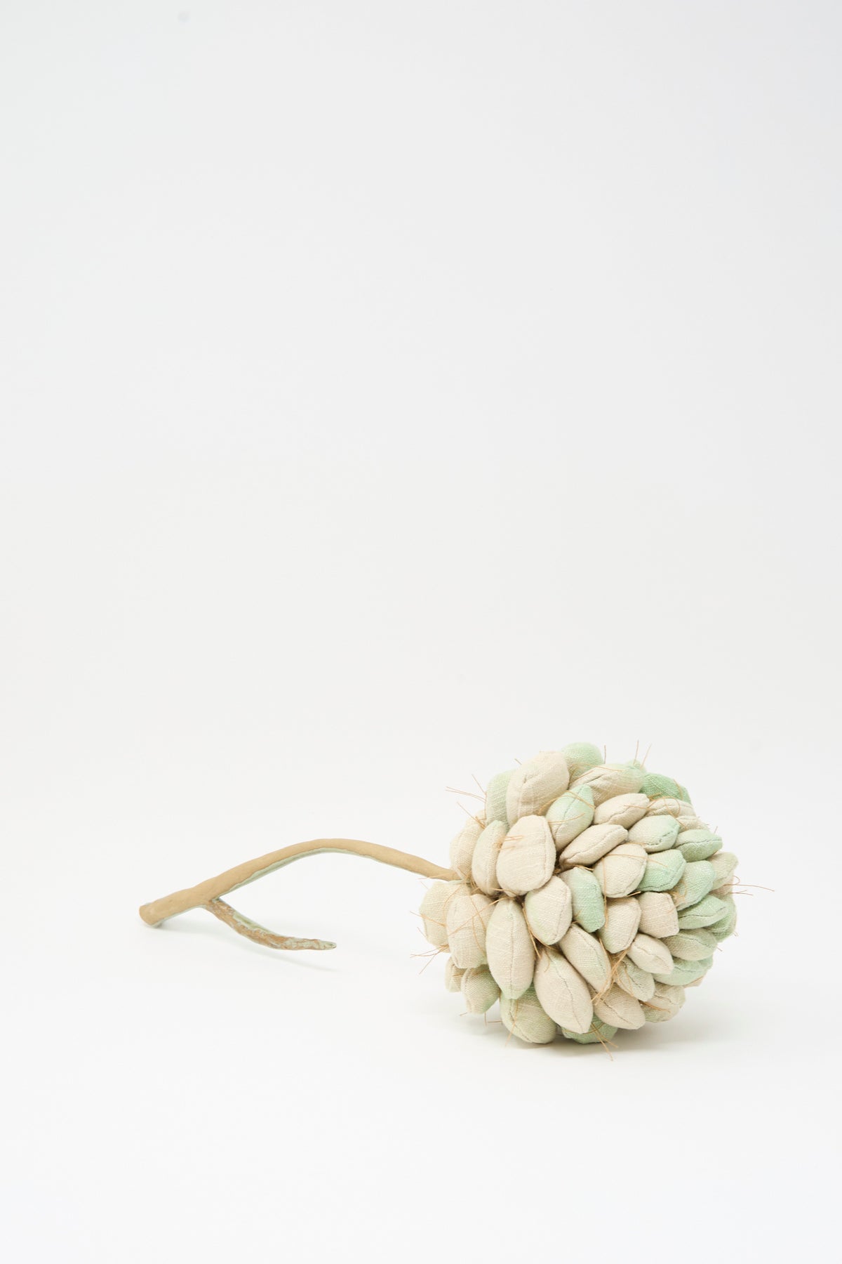 Tamar Mogendorff Pine Cone No. 2, a handmade fabric pine cone ornament with overlapping scales on a small stem.