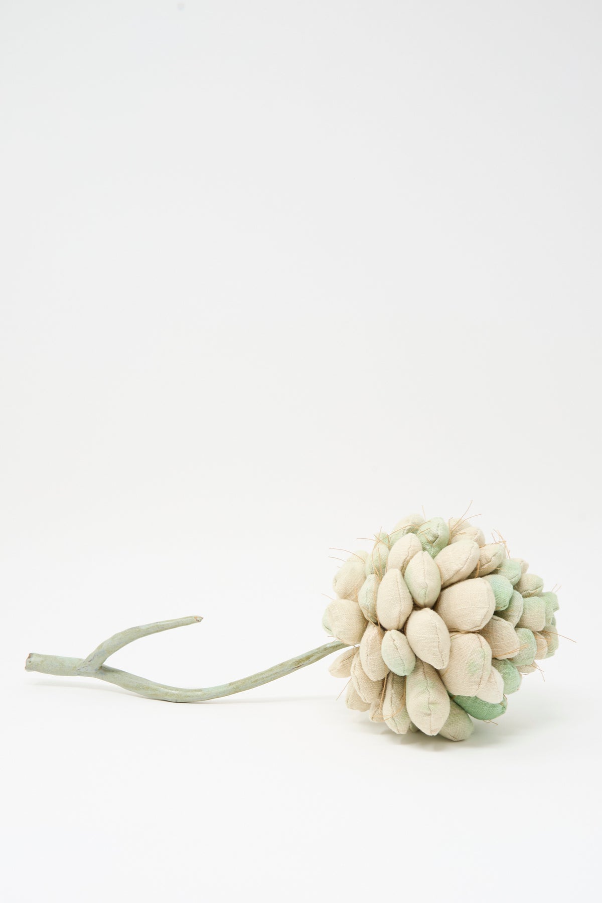 Tamar Mogendorff Pine Cone No. 2, a soft sculpture with a stem and segmented fabric scales in cream and pale green.