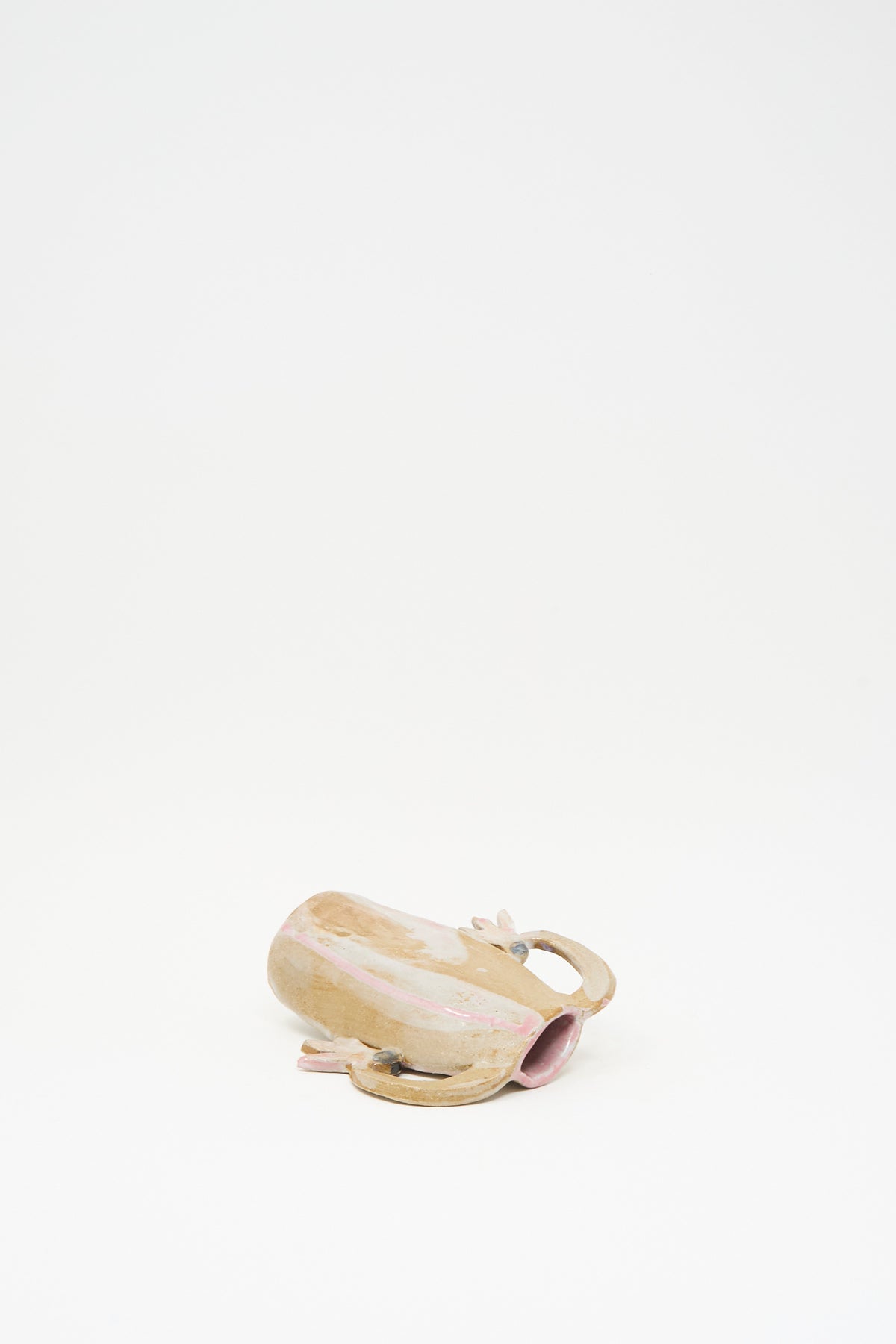 A handmade Tamar Mogendorff Pink Cyclamens Vase with pink accents and a multicolored glaze lying on its side.