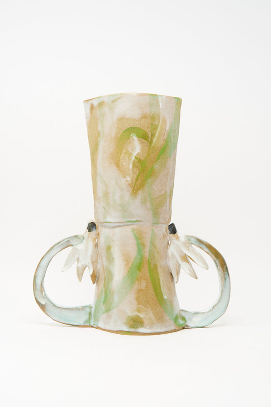 Introducing the Two Cyclamens by the Lake Vase by Tamar Mogendorff—a handmade ceramic piece inspired by Brooklyn’s creative spirit, showcasing abstract green and beige patterns and two sculptural side handles reminiscent of stylized leaves or wings.