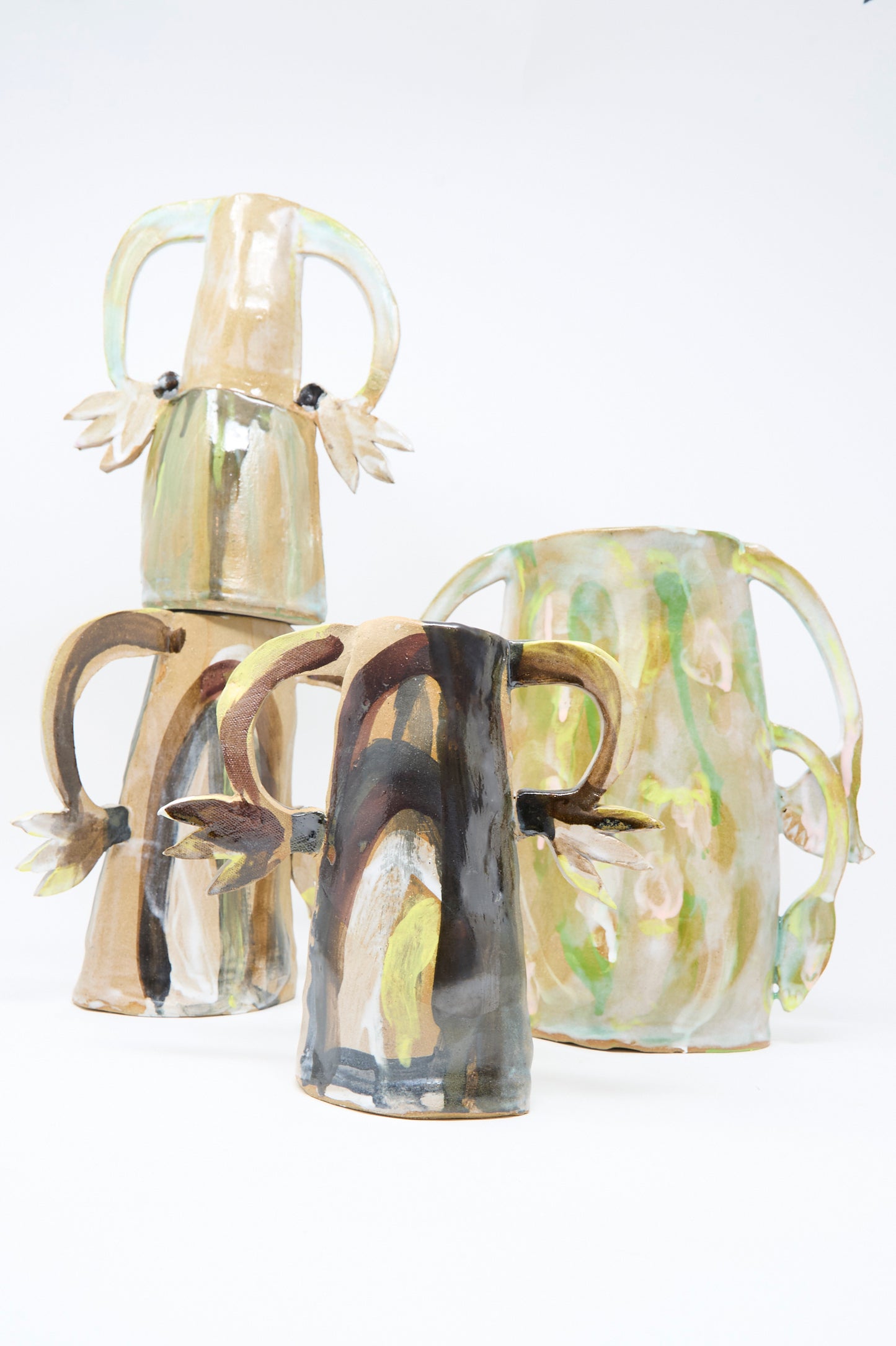 The "Two Cyclamens on Top of a Mountain Vase" by Tamar Mogendorff features organic, irregular shapes and earthy tones, evoking handmade artistry and Brooklyn style against a plain white background.