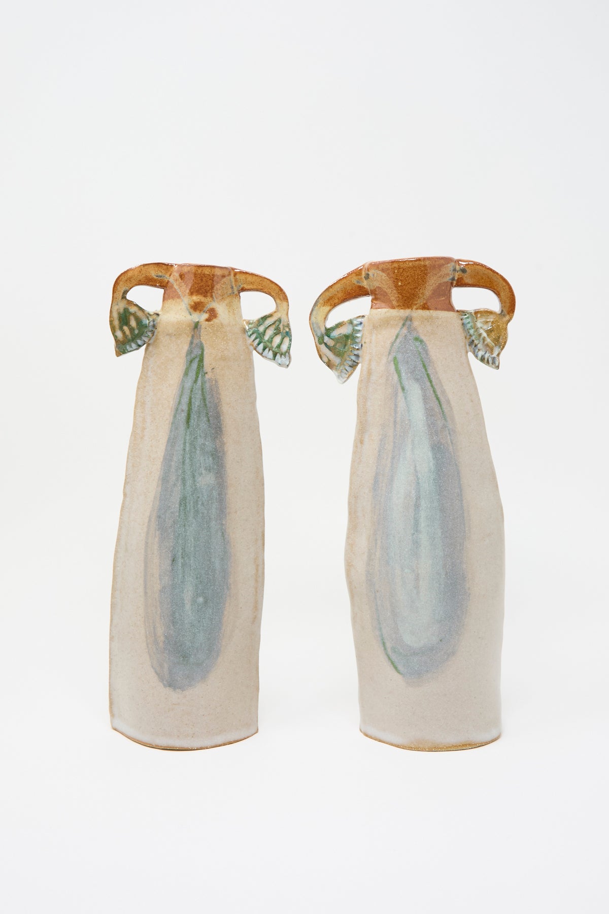 Two Papyrus Candle Holders, a pair of tall, slender handmade ceramic candle holders featuring arched handles and multicolored glazed blue-green accents.