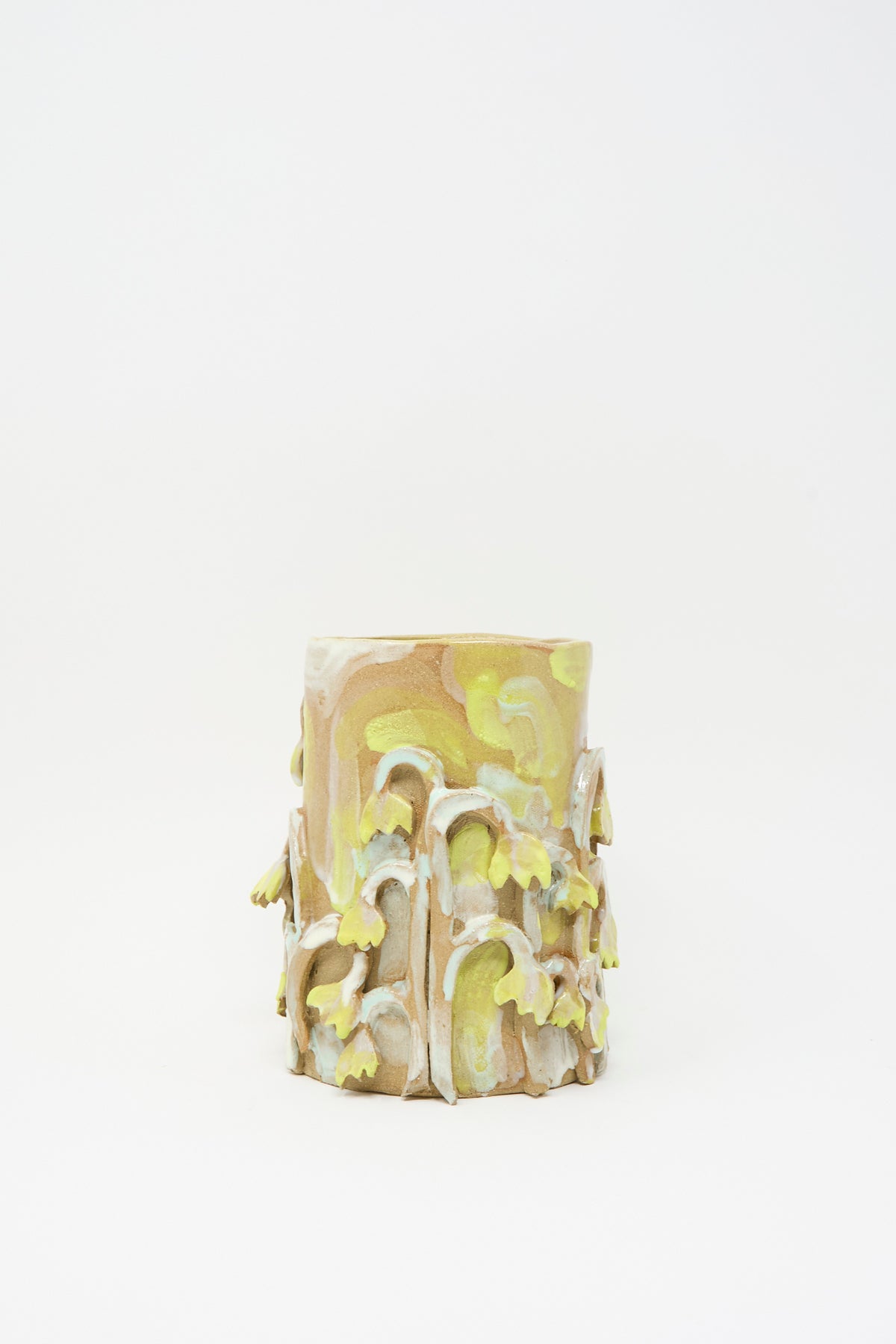 Tamar Mogendorff Yellow Fritillaria Vase, a cylindrical handmade ceramic piece with a tan base decorated with applied yellow and pale green sculptural flower embellishments.