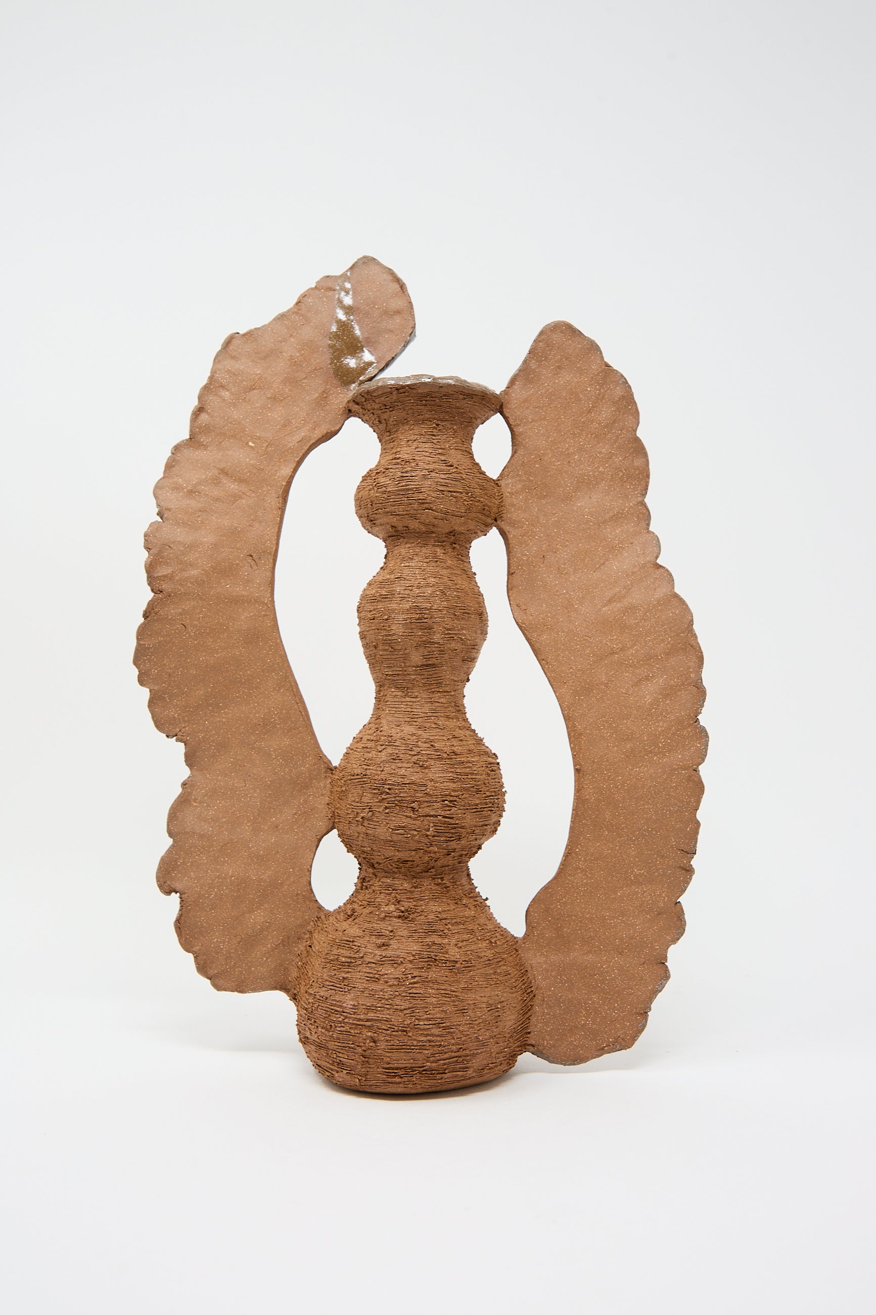 A textured, hand-built red stoneware vase with an abstract design, featuring a central, curvy column flanked by two large, irregular wings, The Flying Ra Vase by Tania Whalen.