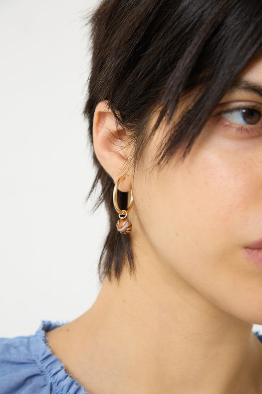 A woman wearing Tara Turner gold hoop earrings.