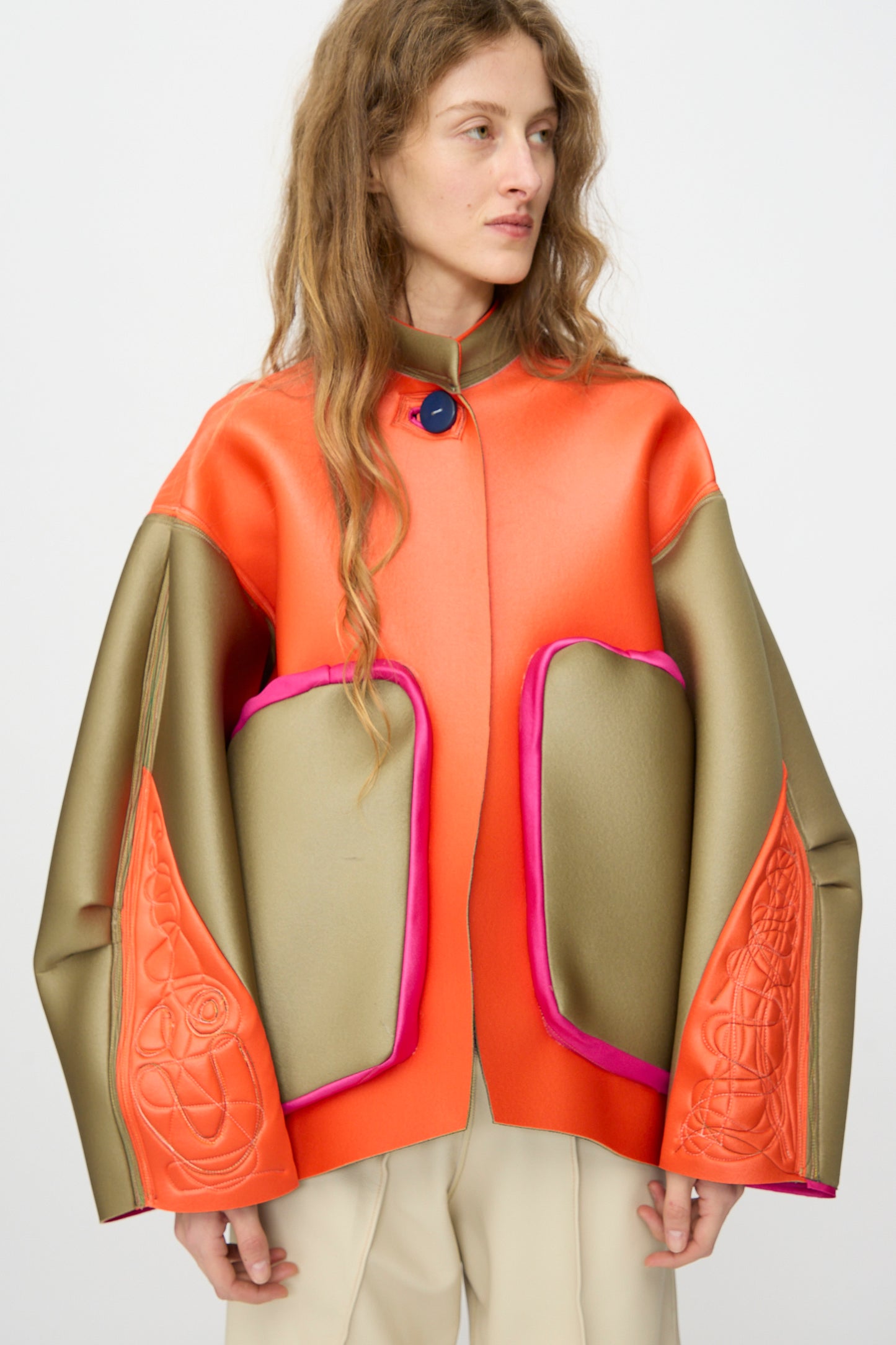 A person wearing the Thank You Have A Good Day Color block Cropped Parka with orange, gold, and pink accents stands against a plain background, looking to the side.