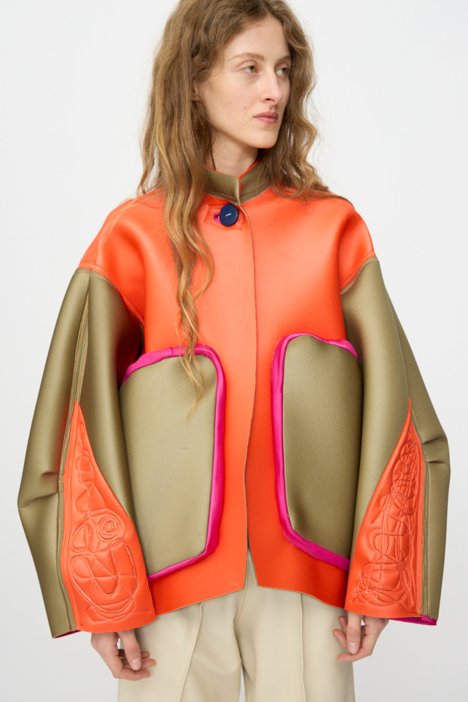 A person wearing the Thank You Have A Good Day Color block Cropped Parka with orange, gold, and pink accents stands against a plain background, looking to the side.