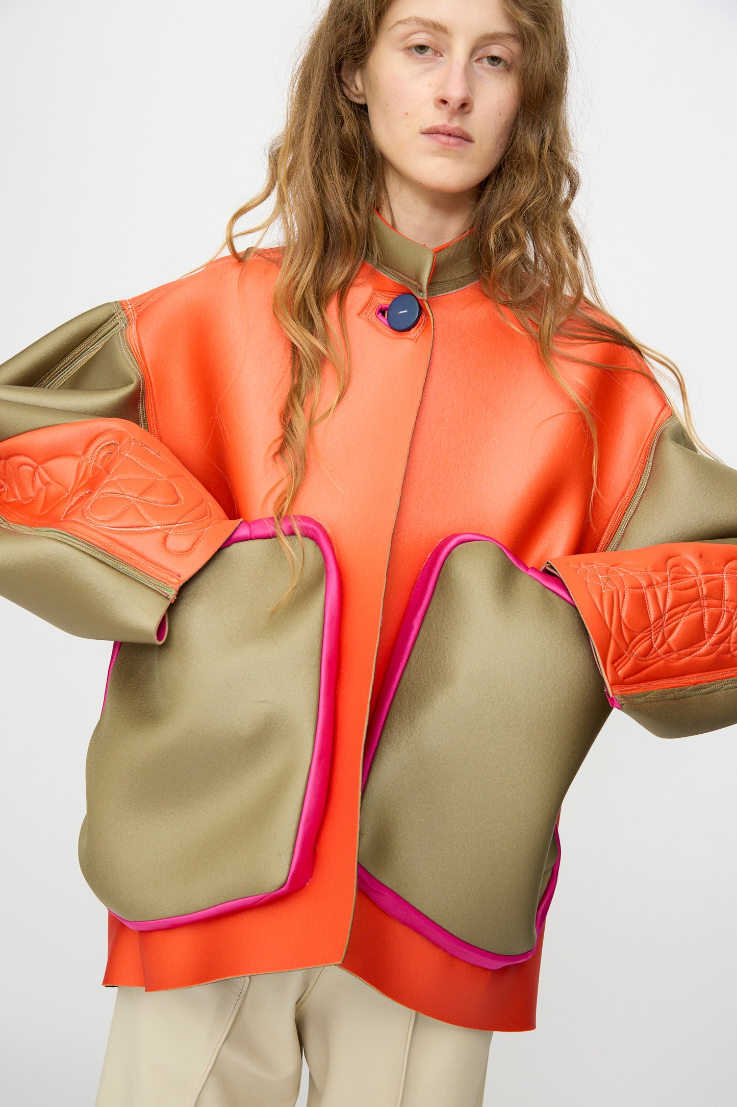 A person with long hair wears the Thank You Have A Good Day Color block Cropped Parka with orange, olive green, and pink panels over beige pants, standing against a white background.