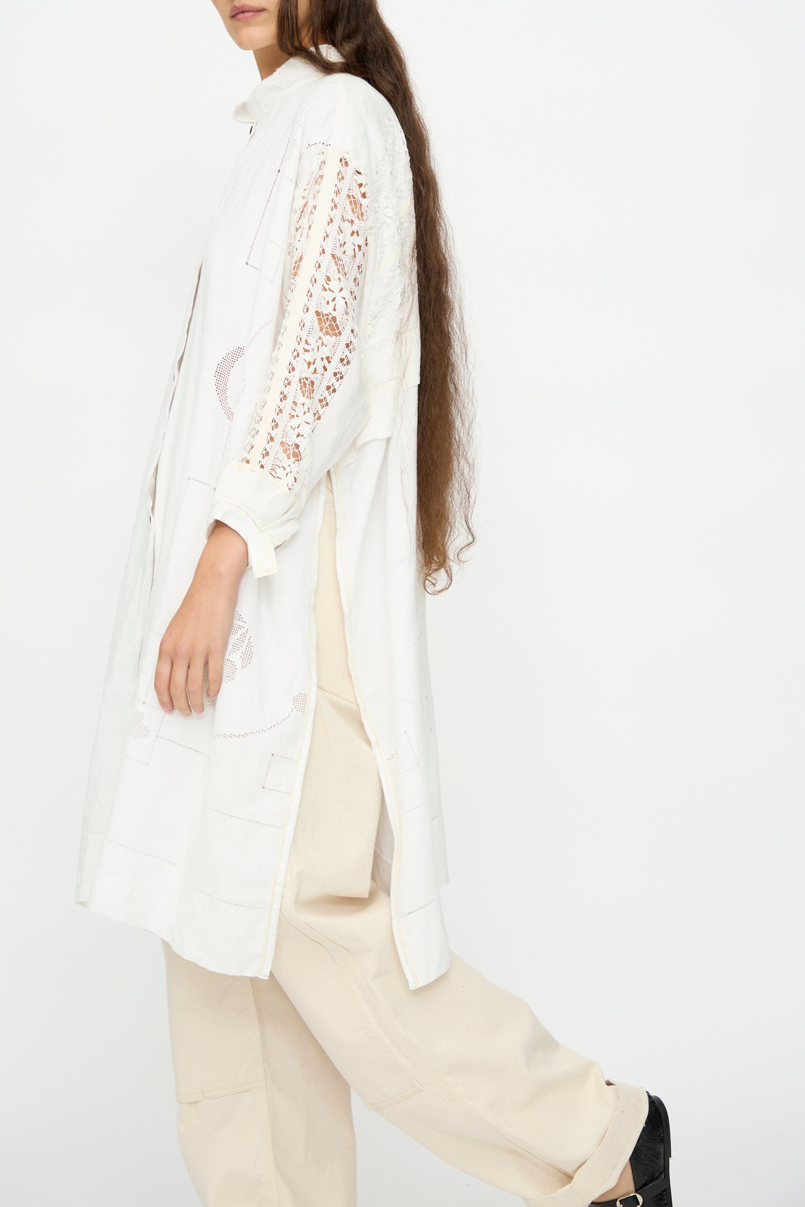 A person with long brown hair wears the Thank You Have A Good Day Heart and Flower Oversized Oxford shirt, cream pants, and black shoes, standing against a plain white background.