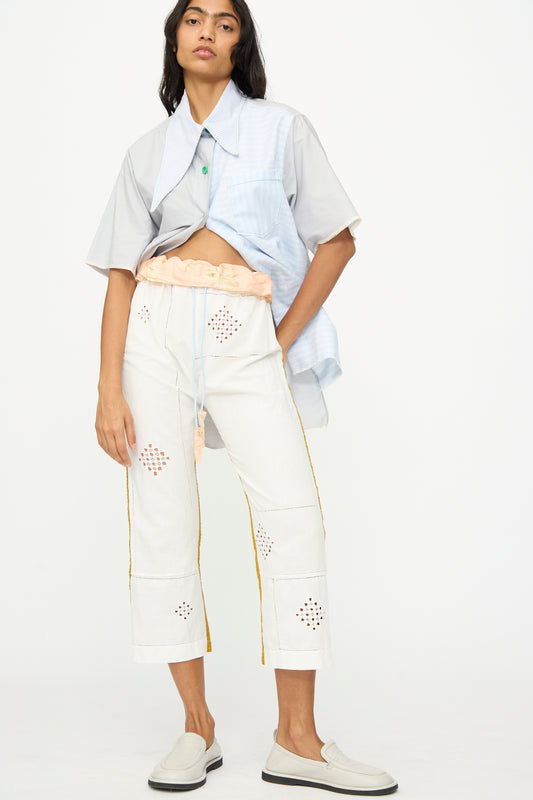 A person wears a loose short-sleeve shirt over a cropped top, paired with the handmade Lounge Pant by Thank You Have A Good Day, featuring cutout patterns, and light slip-on shoes, all photographed against a plain background.