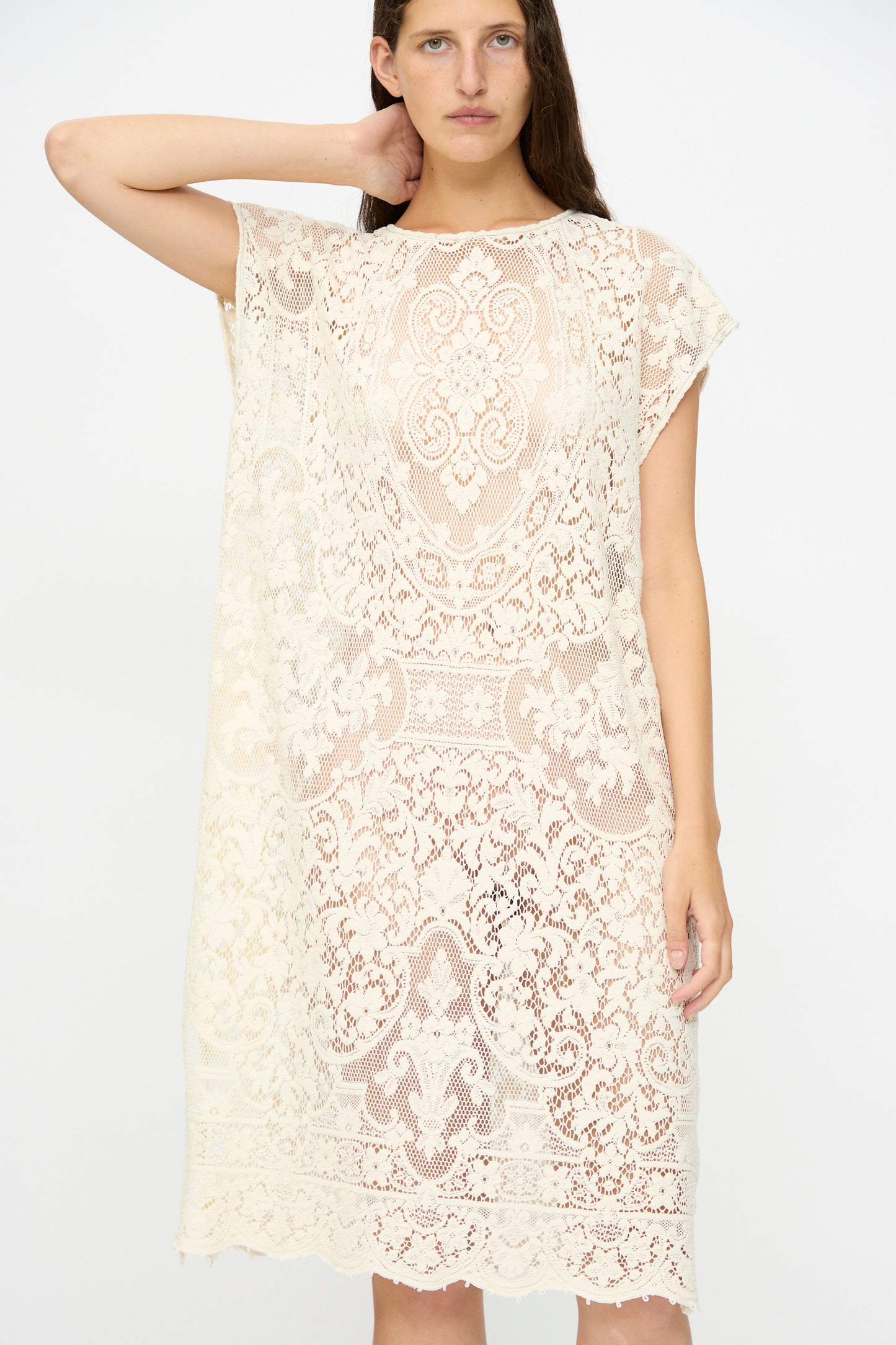 A woman poses against a plain background in the Thank You Have A Good Day Quaker Lace Caftan Midi Pullover, a loose, knee-length cream dress crafted from intricate antique Quaker lace.