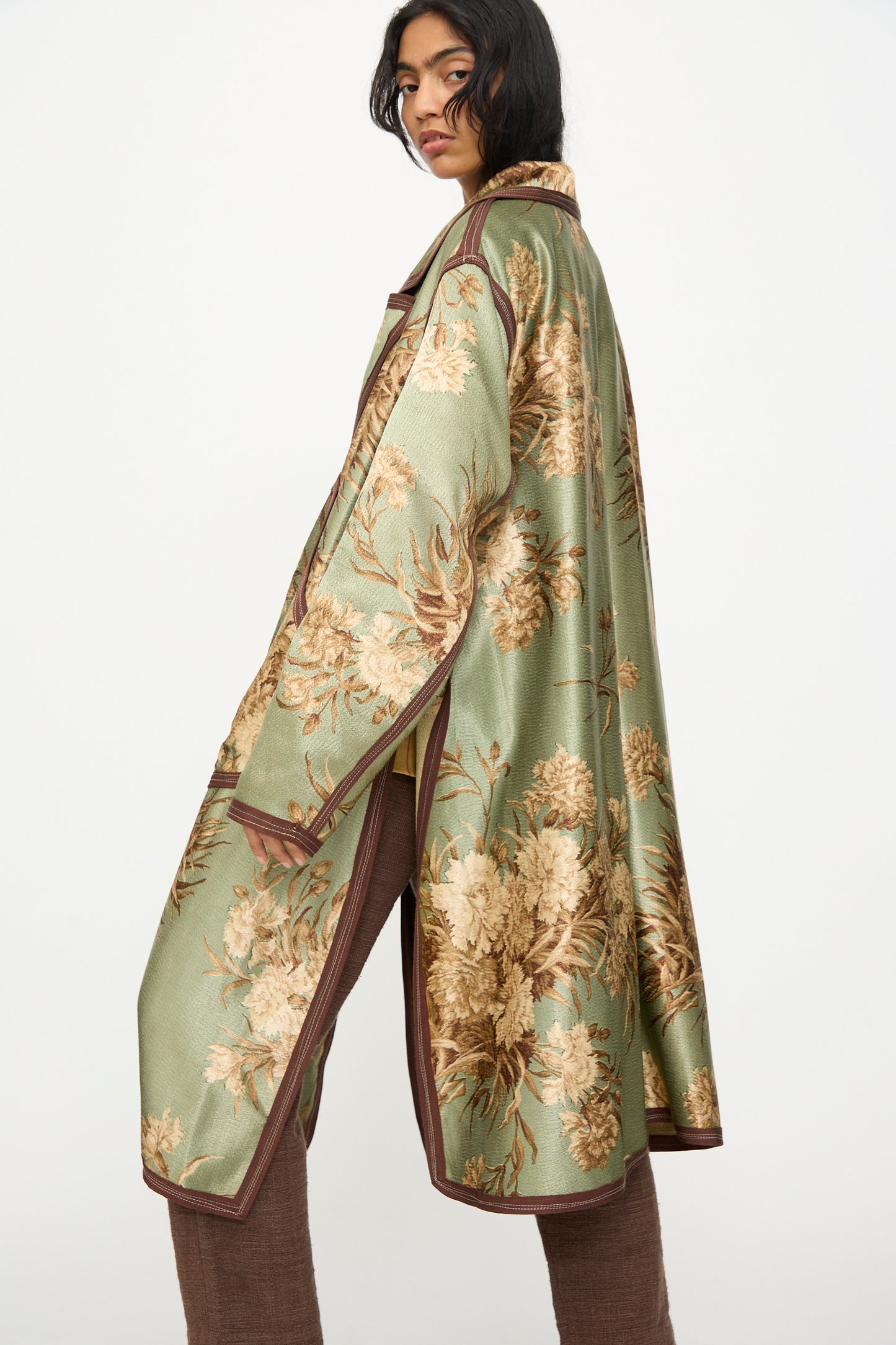 Wearing the Thank You Have A Good Day Taped Trench in Floral, this person stands sideways against a plain white background.