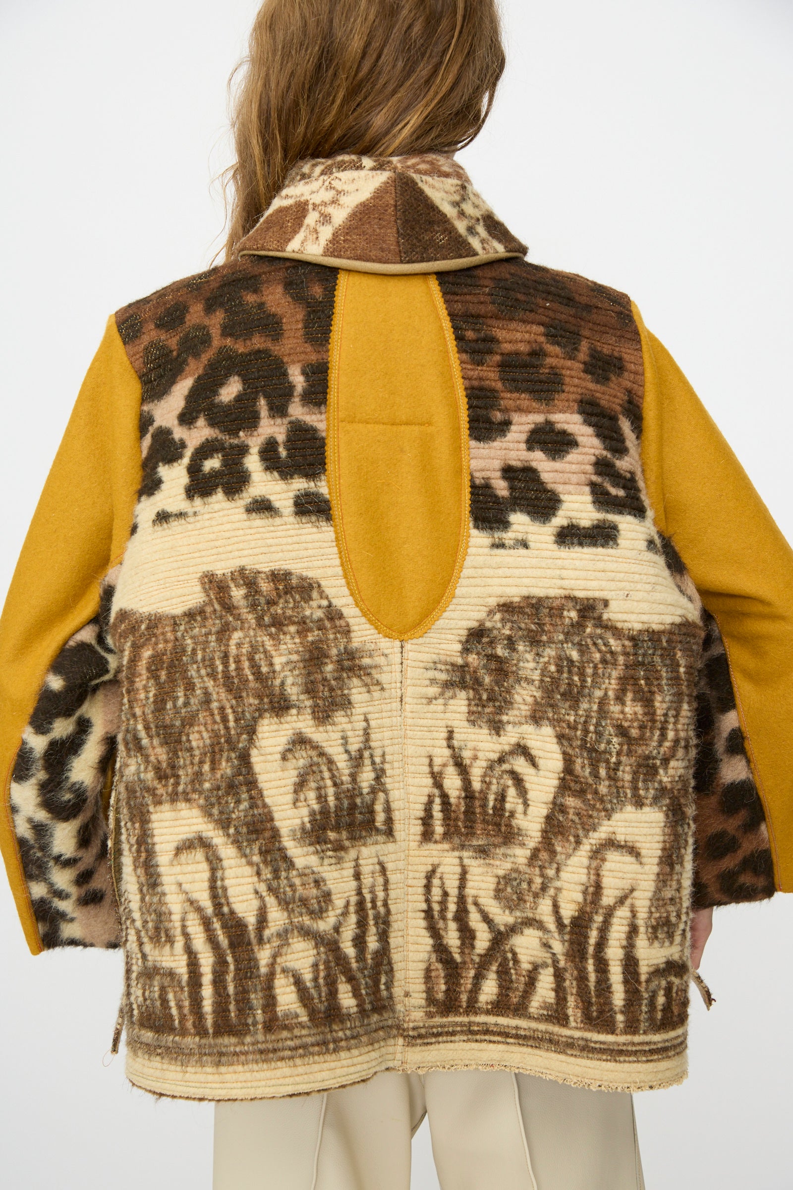 Person wearing the Tiger Topper Jacket by Thank You Have A Good Day, a handmade piece with animal print and two lion-like figures on the back, inspired by 1930s wool tiger blanket jackets, shown from behind against a plain background.