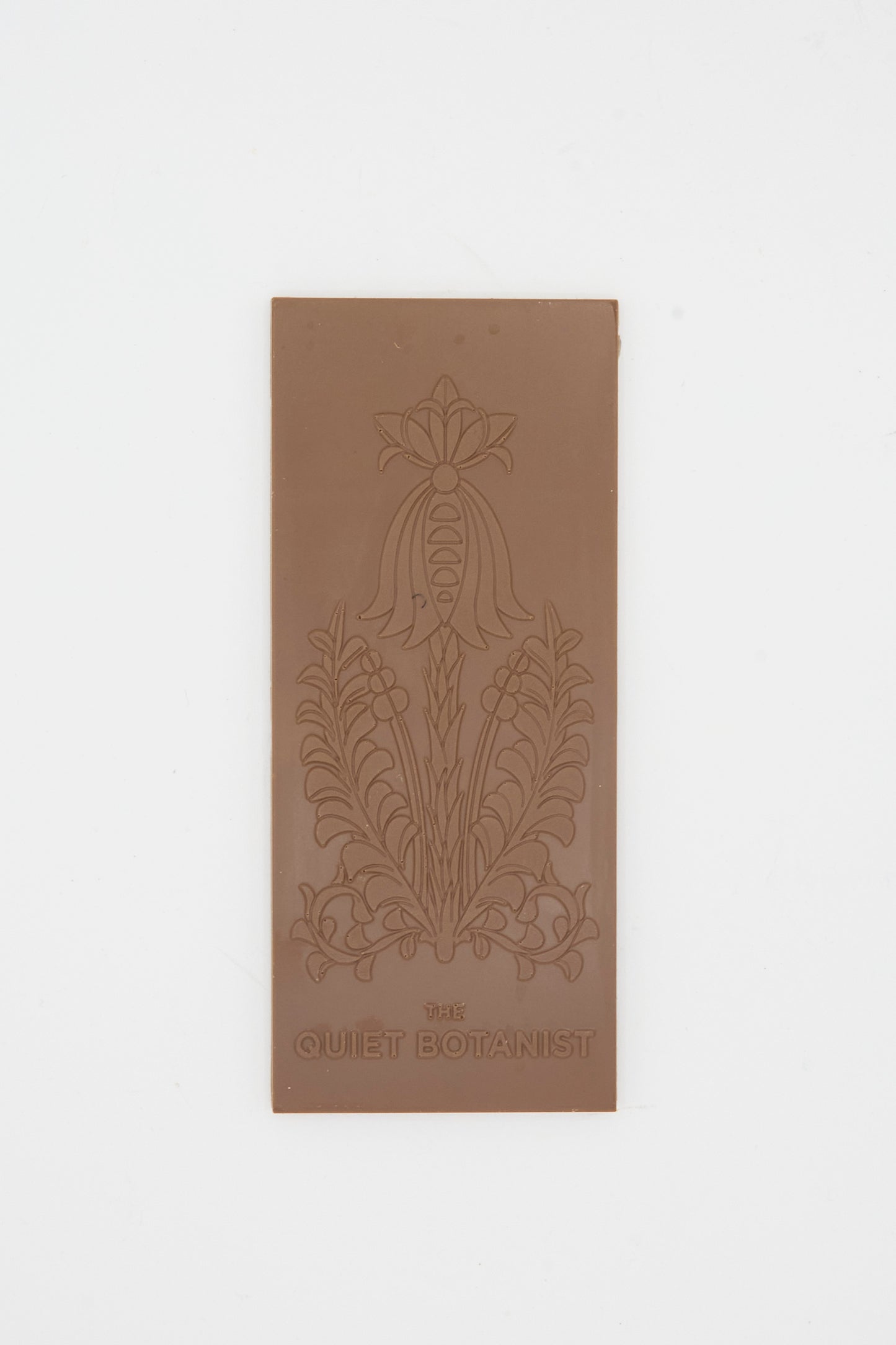 The Easter Milk Bar by The Quiet Botanist is a rectangular milk chocolate bar with an embossed floral design and the brand’s name at the bottom.