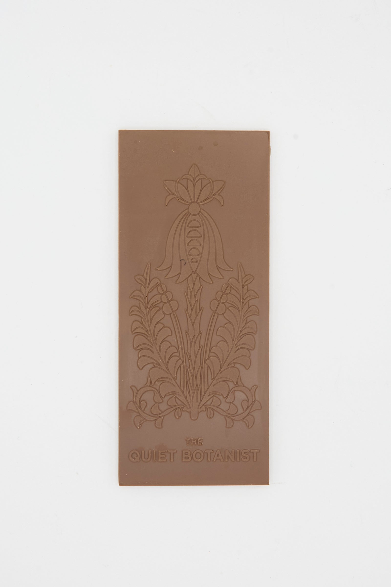 The Easter Milk Bar by The Quiet Botanist is a rectangular milk chocolate bar with an embossed floral design and the brand’s name at the bottom.