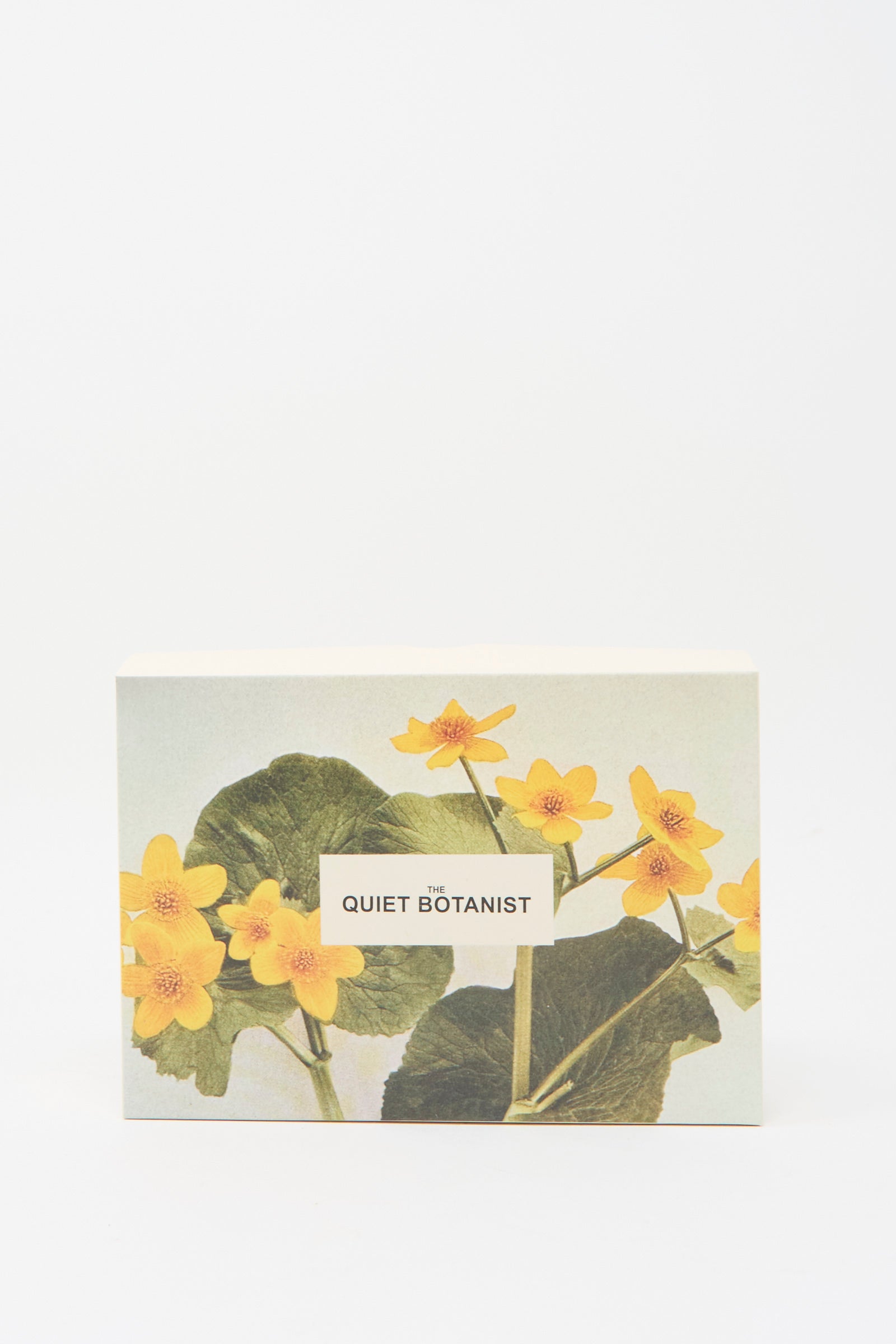 A box labeled "Holiday Bon Bons" by The Quiet Botanist, featuring an illustration of yellow flowers and green leaves against a white background.