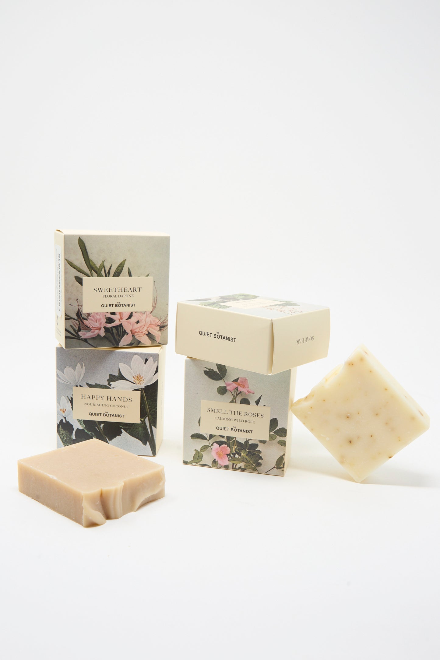 Three Mother Nature Wild Pistachio Soap Bars by The Quiet Botanist are displayed beside their floral-patterned boxes labeled "SWEETHEART," "HAPPY HANDS," and "SMELL THE ROSES" on a white background.