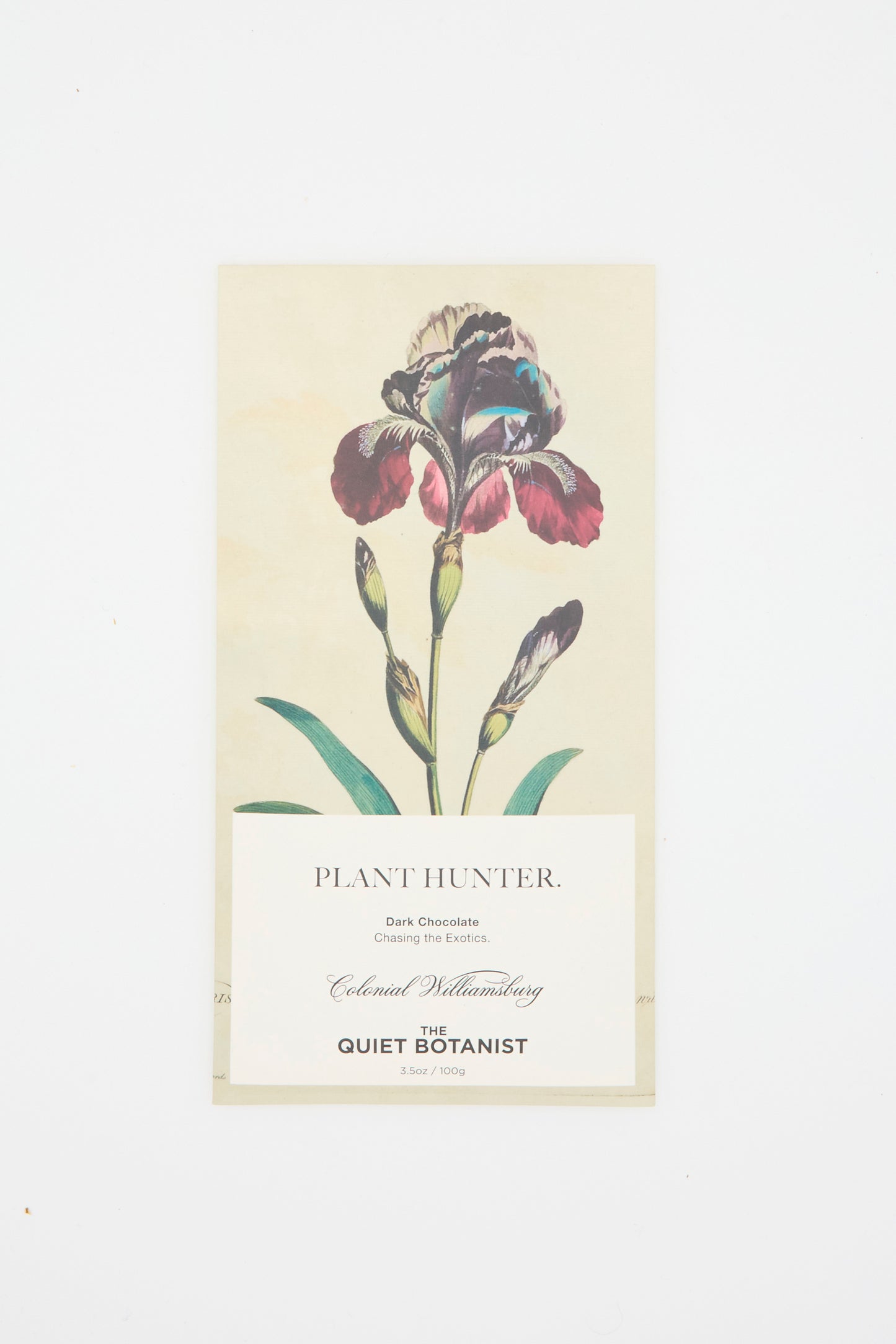 A chocolate bar wrapper featuring a purple iris illustration. The text reads: "Plant Hunter Bar. Dark Chocolate made with organic ingredients. The Quiet Botanist". Against a white background. 