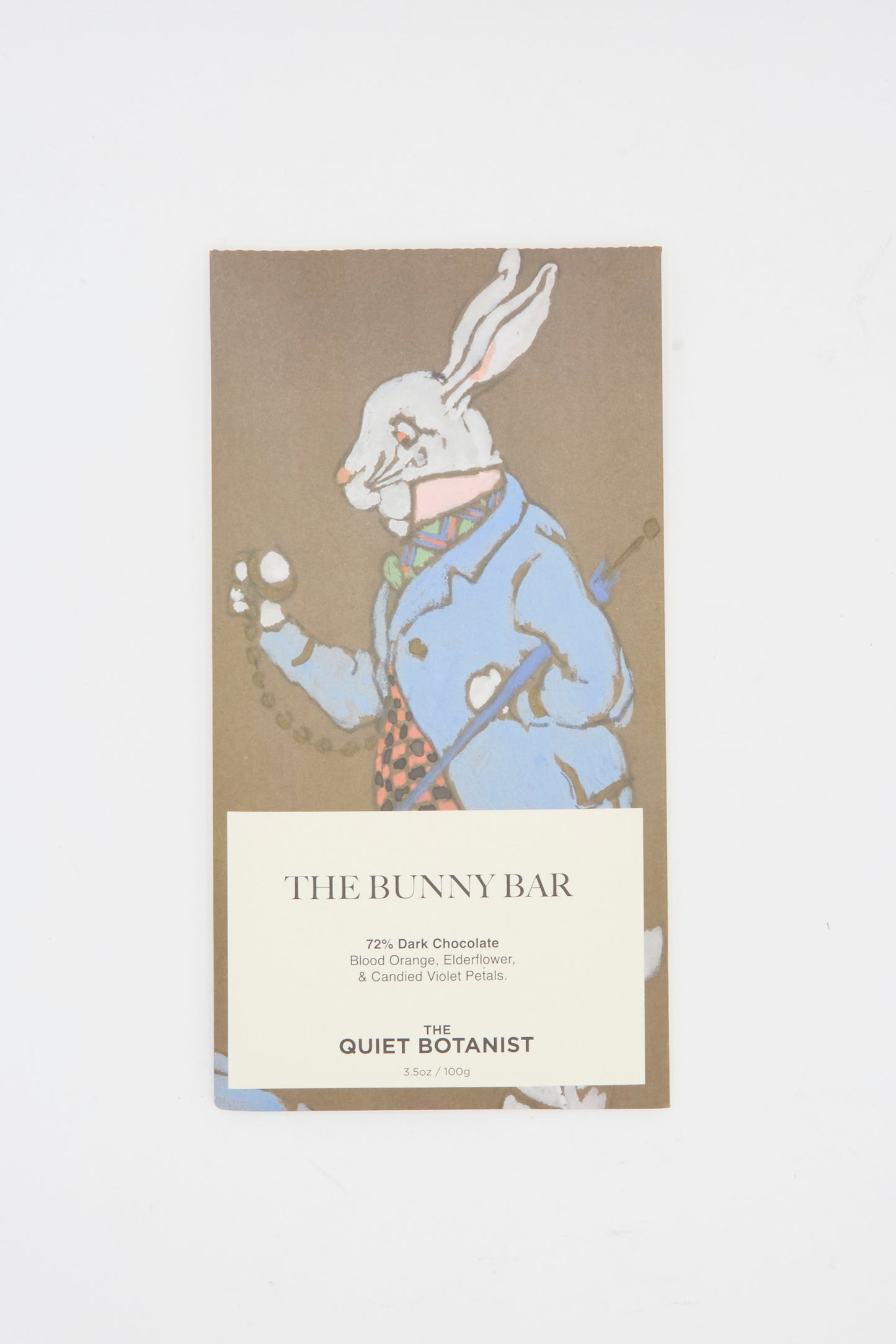 The Quiet Botanist’s The Bunny Bar is a 77% dark chocolate bar infused with botanicals like elderflower, featuring a white rabbit in a blue coat on the package.