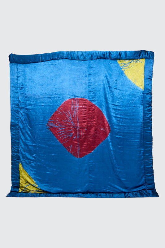 The TIGRA TIGRA Moon Dye Quilt in Jewel Blue, Acid Green, and Magenta features visible stitching details and expert Indian craftsmanship, with bold color contrasts and vibrant accents.