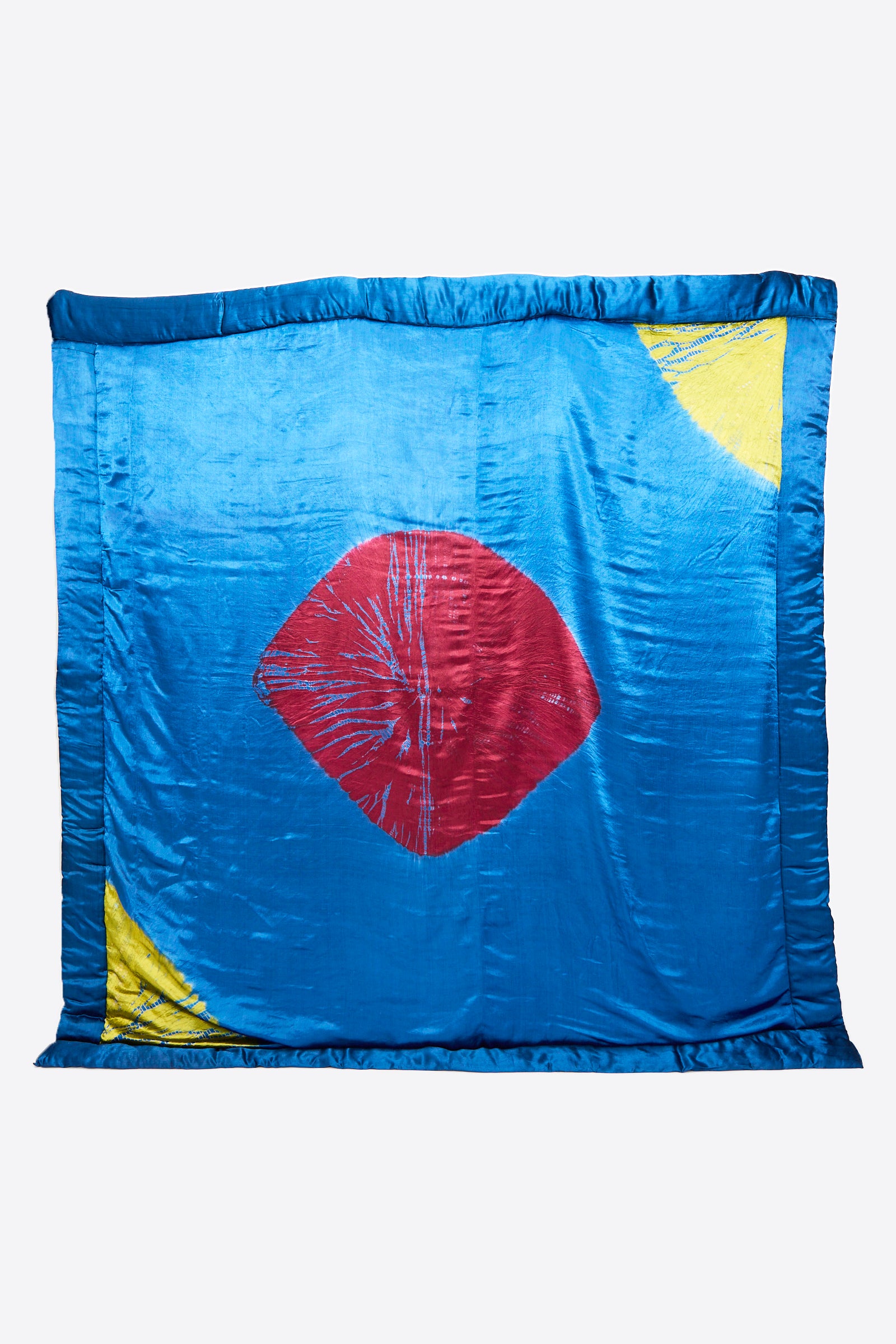 TIGRA TIGRA's Moon Dye Quilt in Jewel Blue features a luxurious sheen, magenta central diamond, and acid green corner accents. Expertly handcrafted in India.