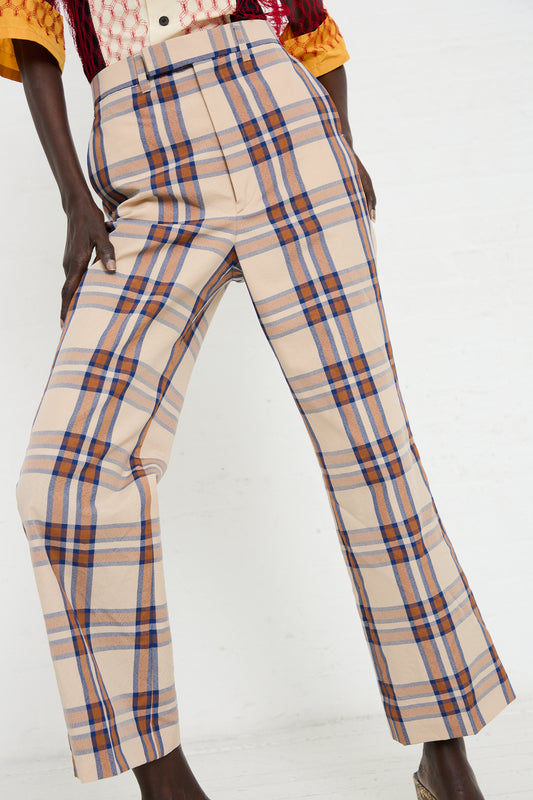 Close-up of a person wearing TOGA Wool Check Pant in Beige. The trousers have a straight leg cut and are paired with a colorful top.