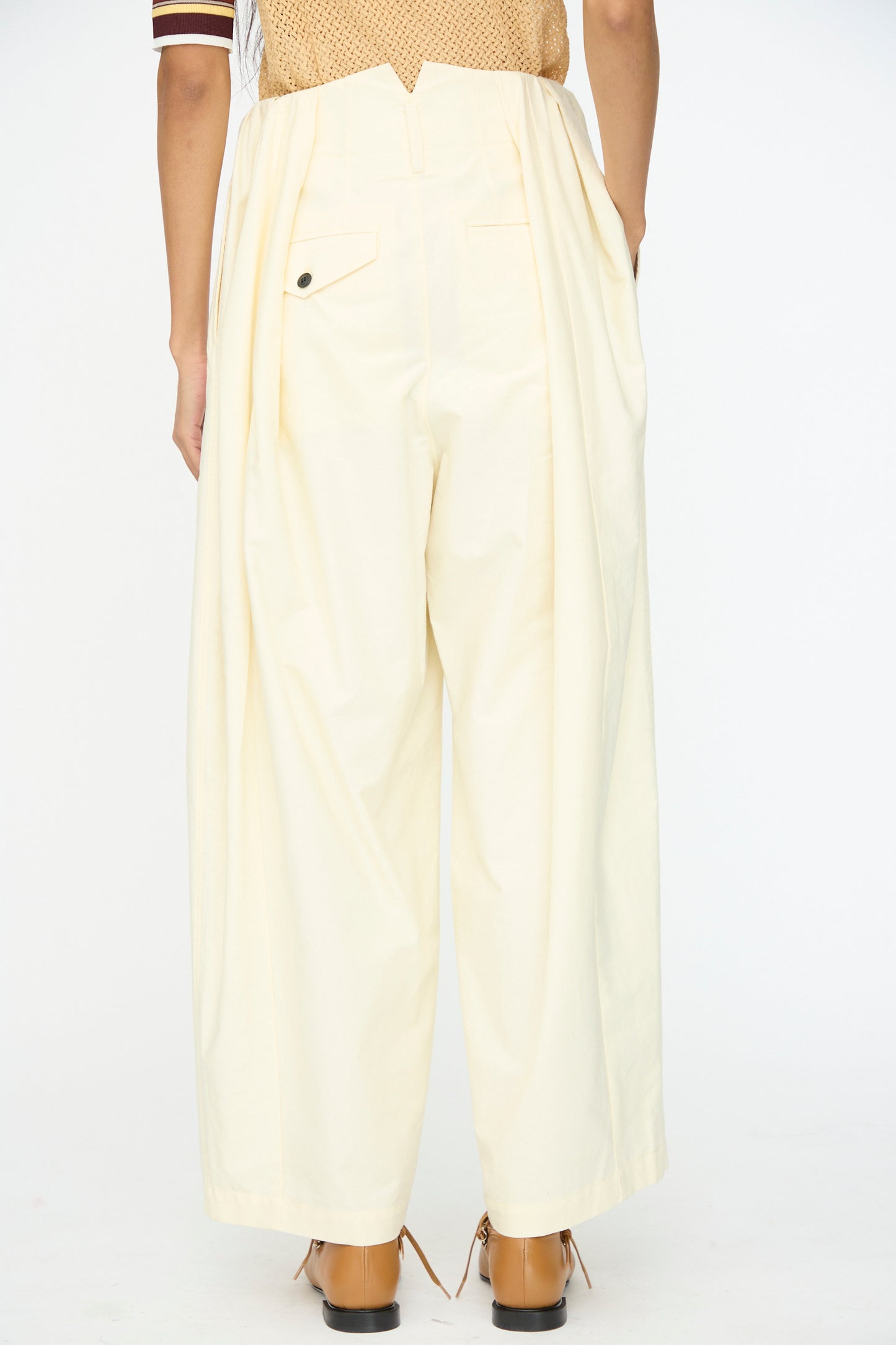 Model wears the Cotton Ox Wide Pant in Off White by TOGA ARCHIVES—an oversized, high-waisted cotton wide-leg pant with back pockets and tan shoes, shown from the rear against a plain white background.