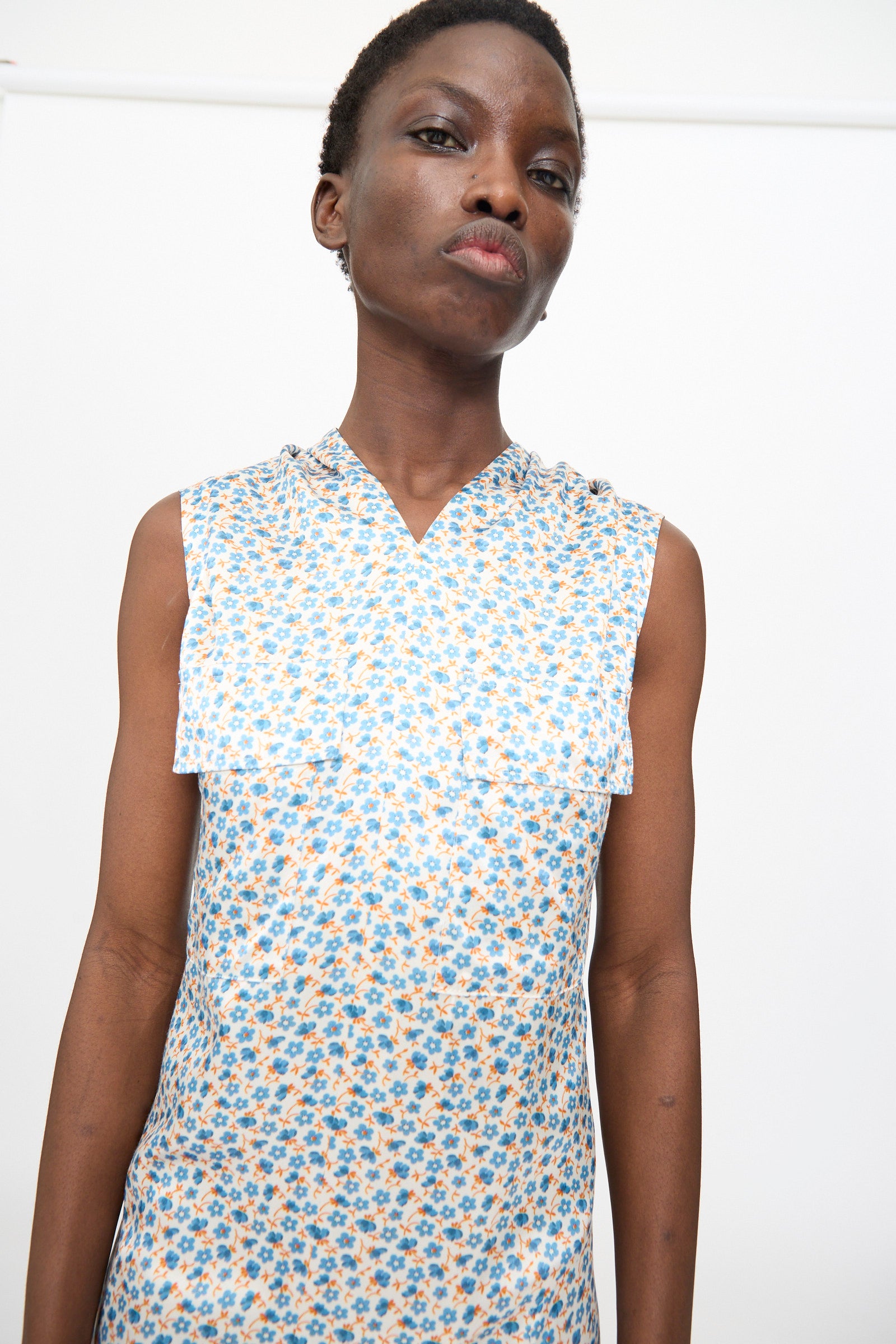 A person wearing the TOGA ARCHIVES Flower Print Dress in White stands before a plain white background.
