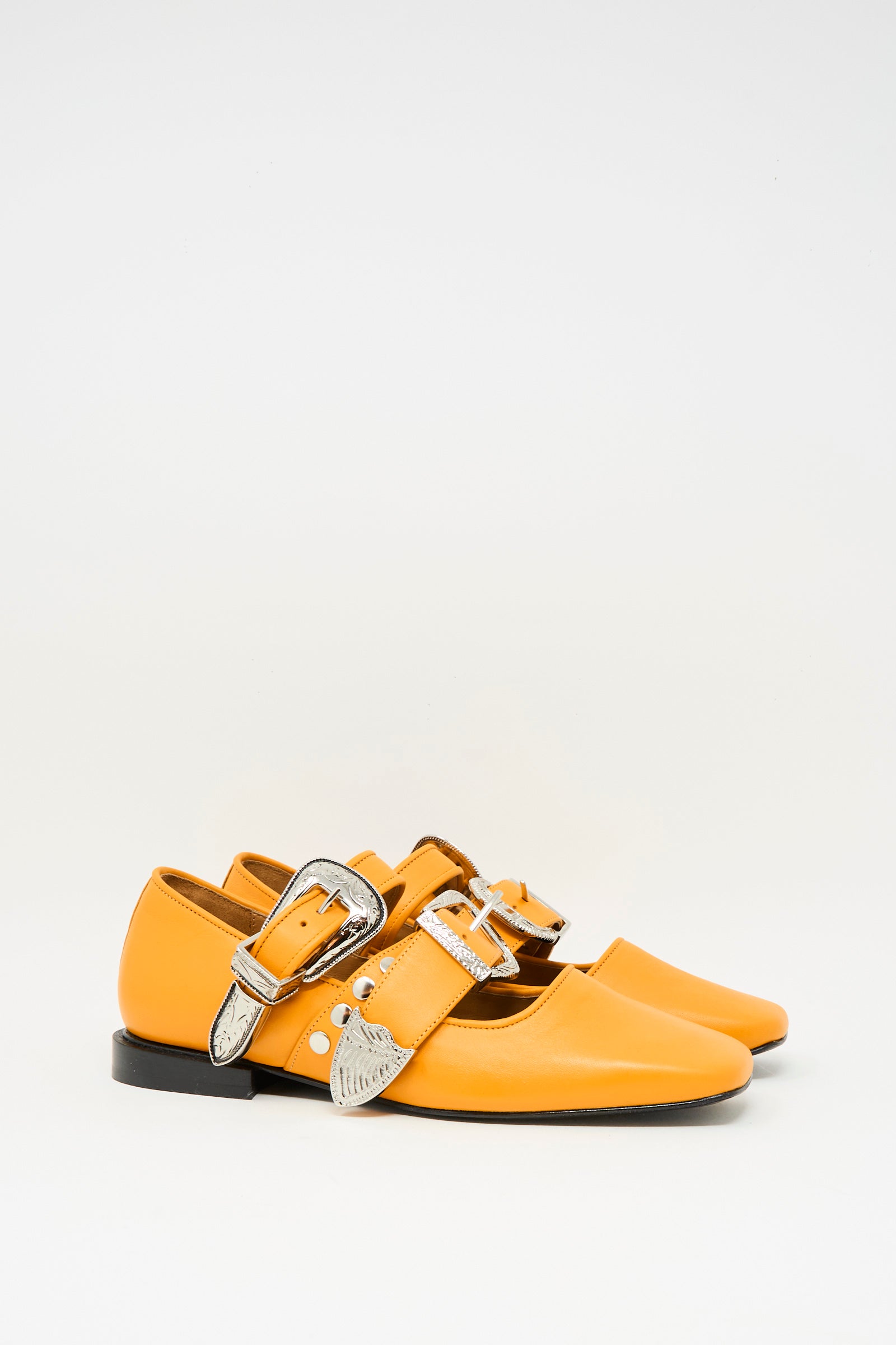 A pair of TOGA ARCHIVES Leather Flats in orange, featuring square toes with silver buckles, displayed side by side on a plain light background.