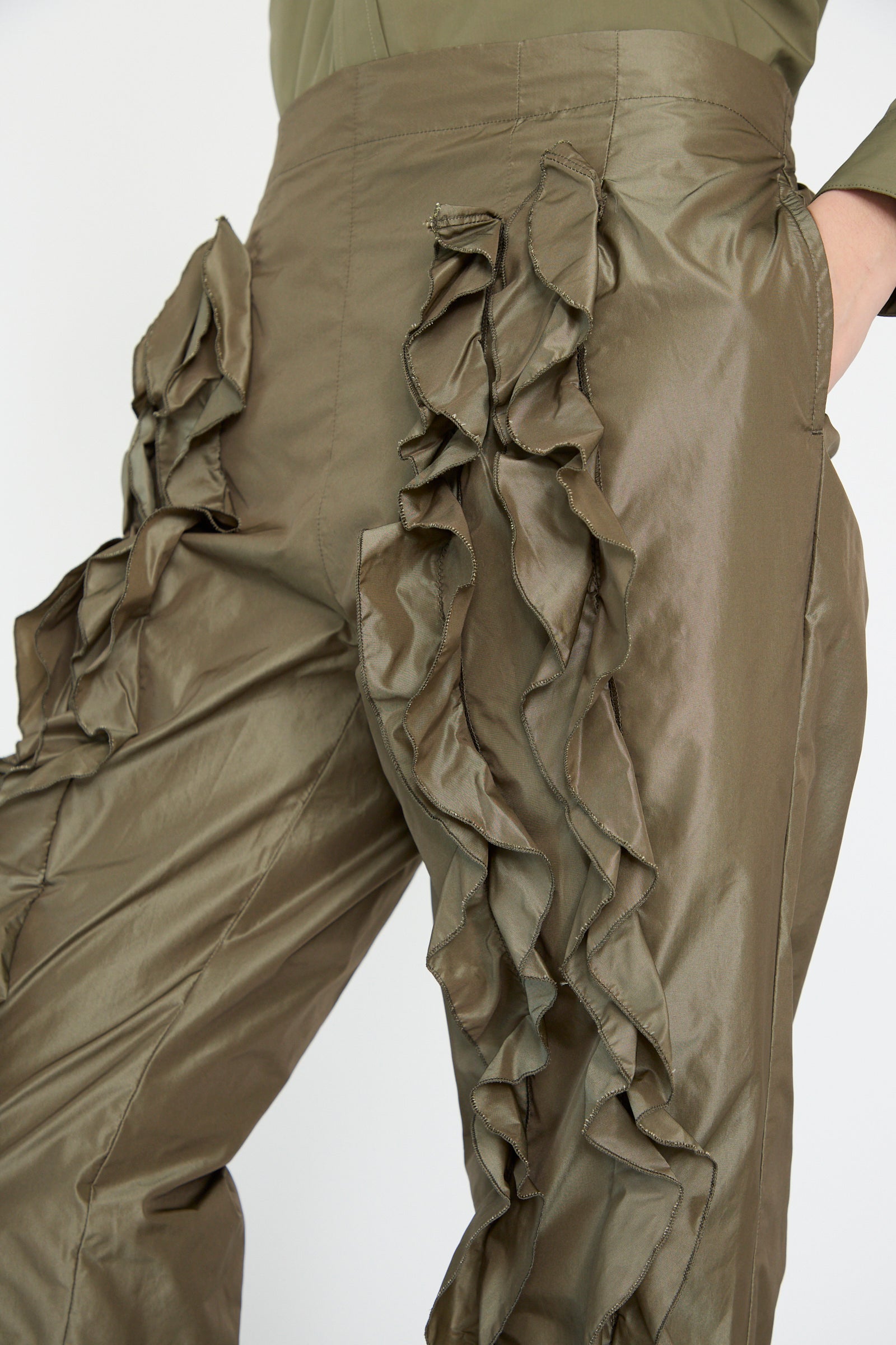 TOGA ARCHIVES' Memory Taffeta Pant in khaki features a relaxed fit with ruffled side detailing, the model has one hand in a pocket. 