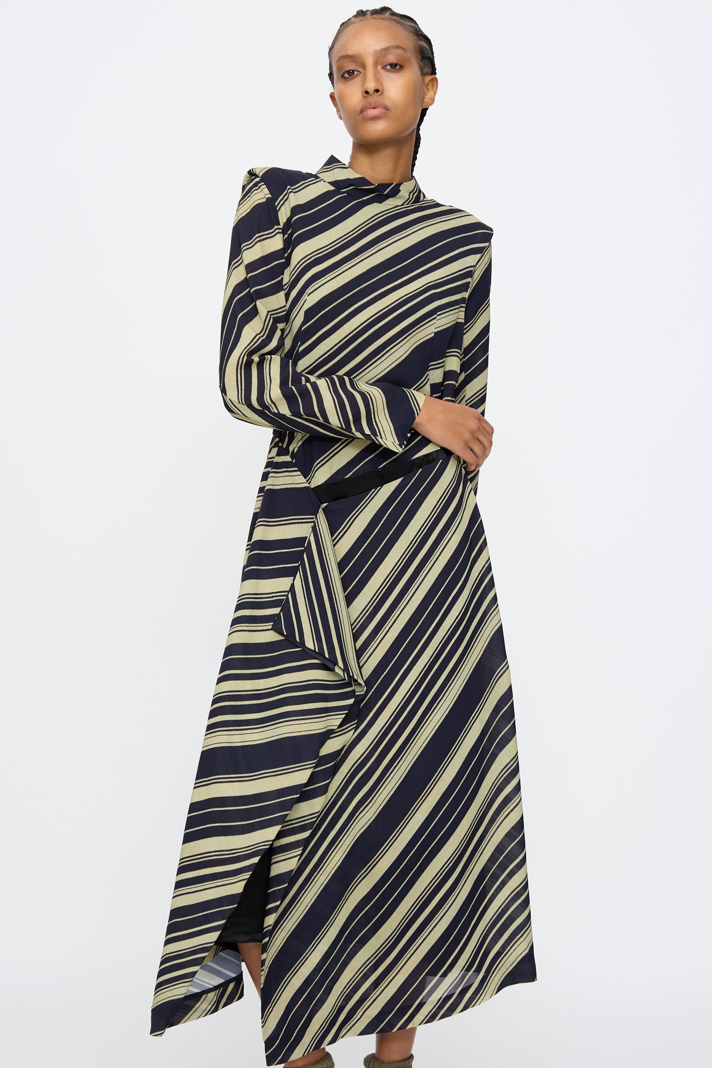A person wearing the TOGA ARCHIVES Rayon Print Dress in Navy stands against a plain white background.
