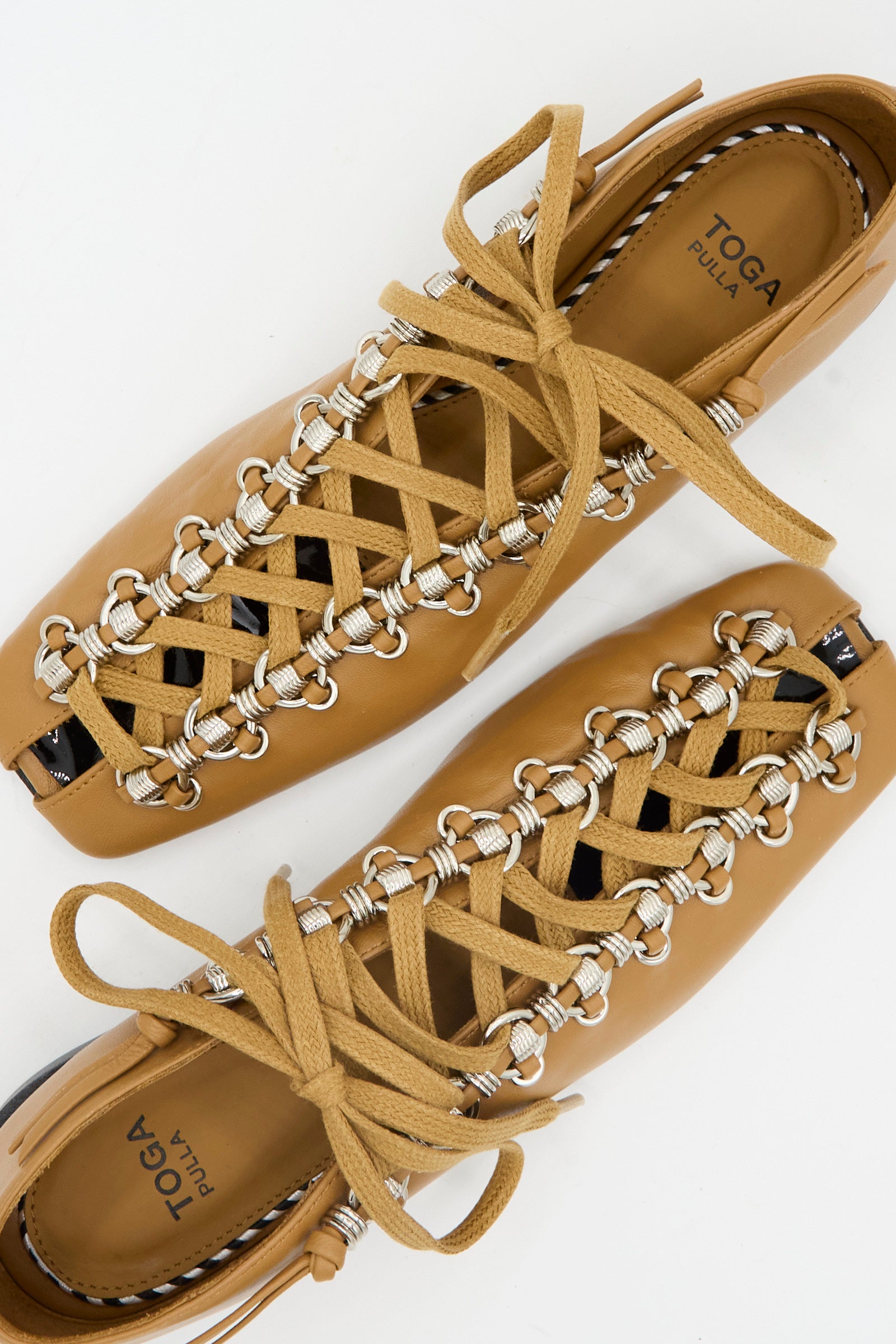 The Soft Leather Shoe in Tan by TOGA ARCHIVES features cowhide leather, beige lacing, silver ring hardware, and a flat sole. Shown from above on a white background. Made in Portugal.