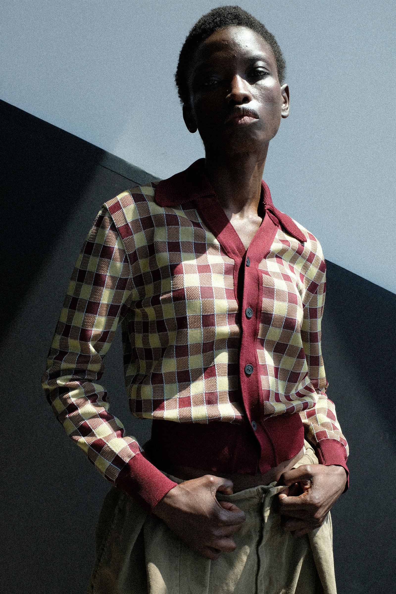 Person wearing the Toga Archives Check Knit Cardigan in Dark Red against a dark background.