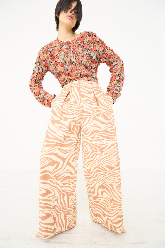 Woman posing in a floral top and Ulla Johnson's Cai Pant in Gazelle.