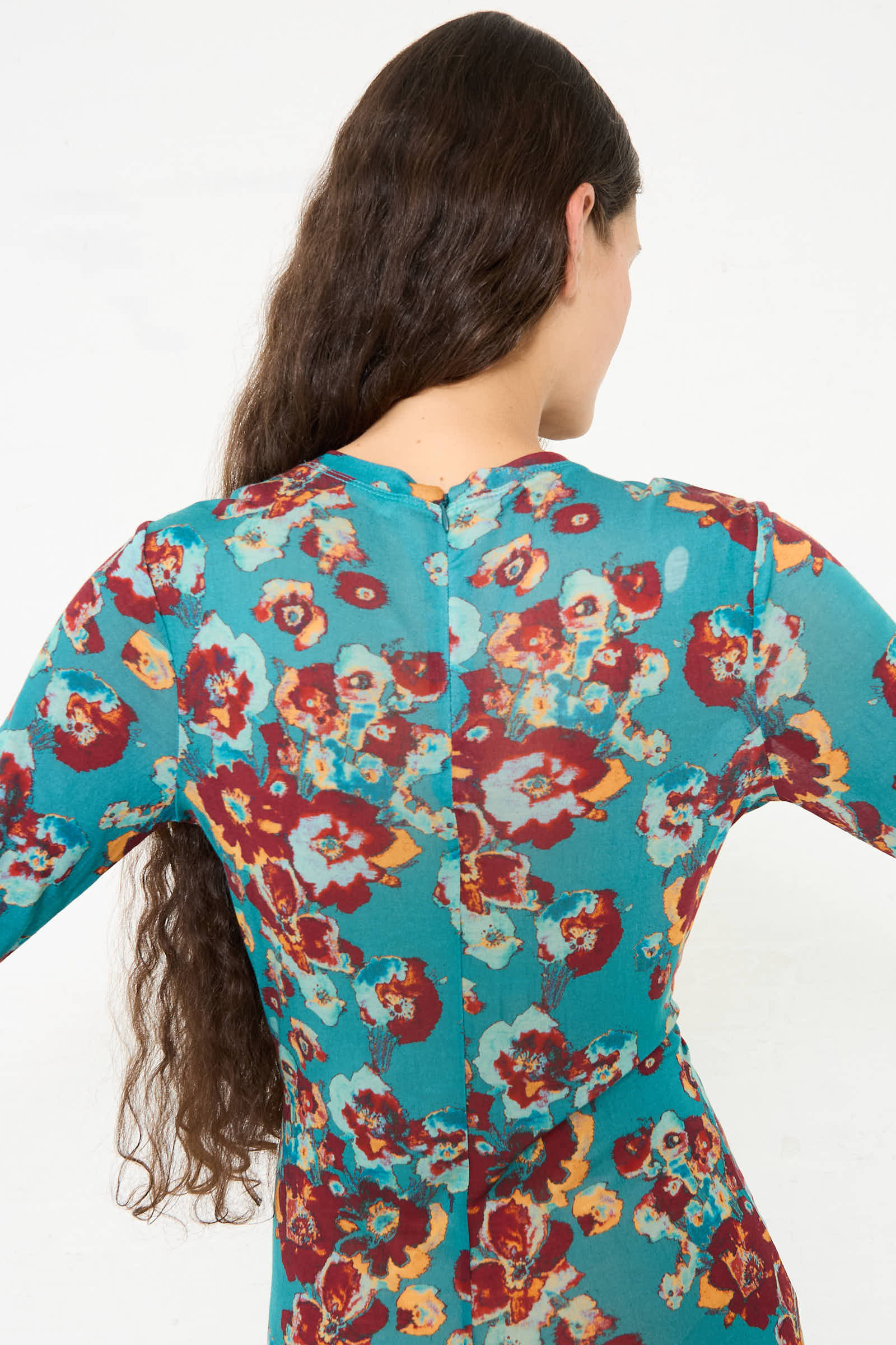 A person with long, wavy hair is shown from the back wearing the Ulla Johnson Ceryse Dress in Jade Floral.