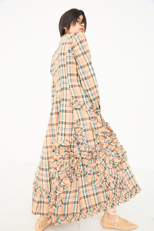 Woman wearing a long plaid maxi shirt dress with ruffle detailing, looking over her shoulder. (Gwen Dress in Meadow by Ulla Johnson)