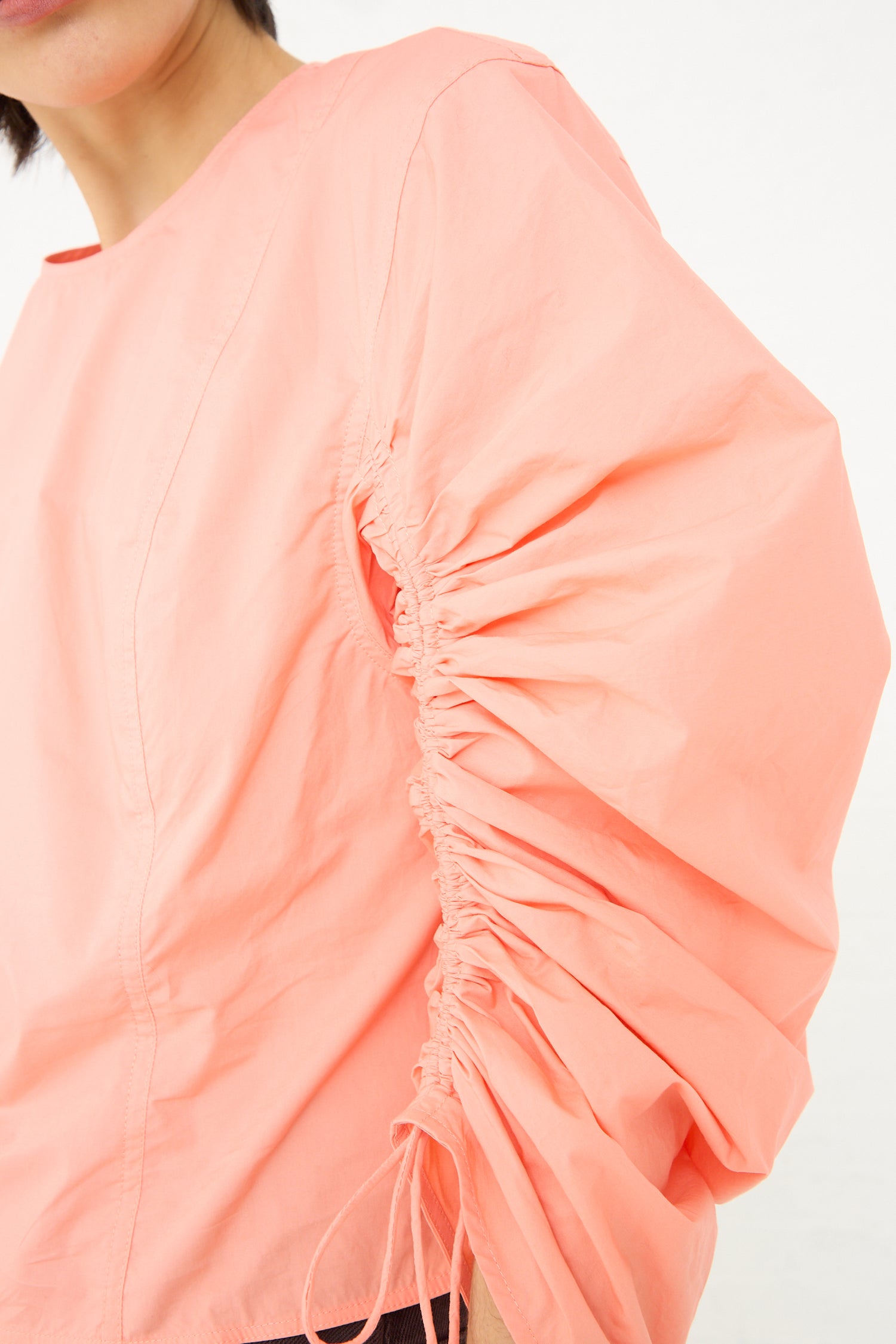 Close-up of a Lorna Blouse in Peony from Ulla Johnson with gathered ruching detail on the sleeve.