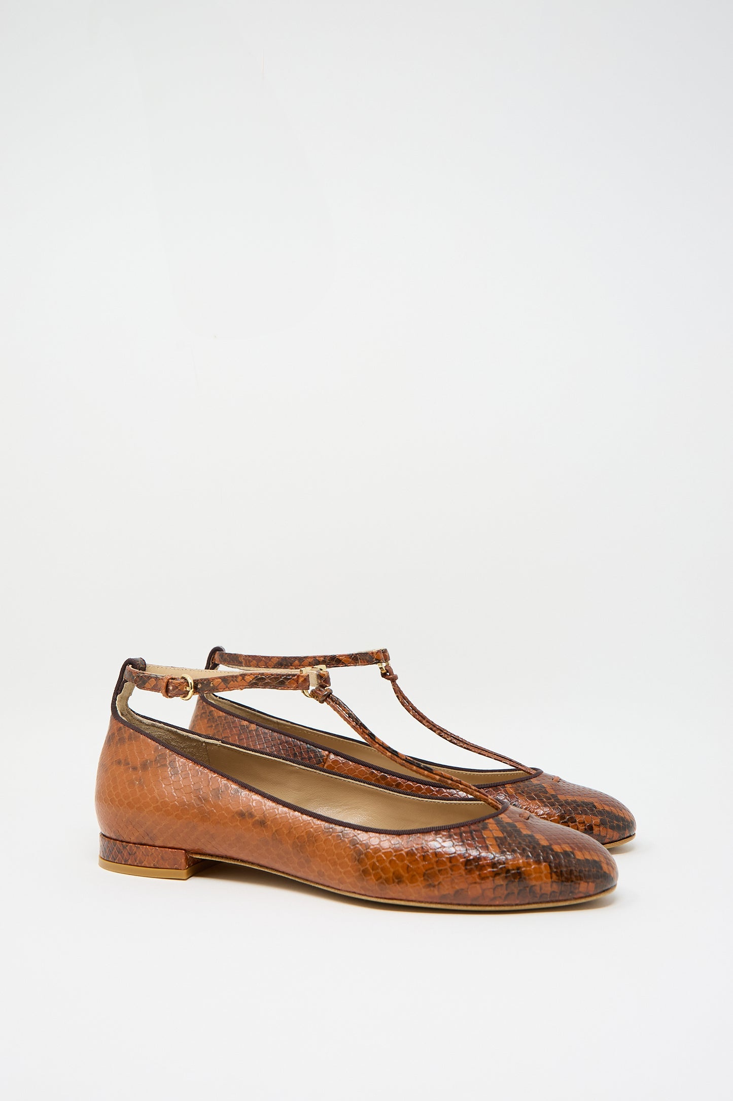 Pair of Mary Jane in Rust Copper by Ulla Johnson, featuring brown animal print leather with an adjustable ankle strap and low heels, displayed against a plain white background.