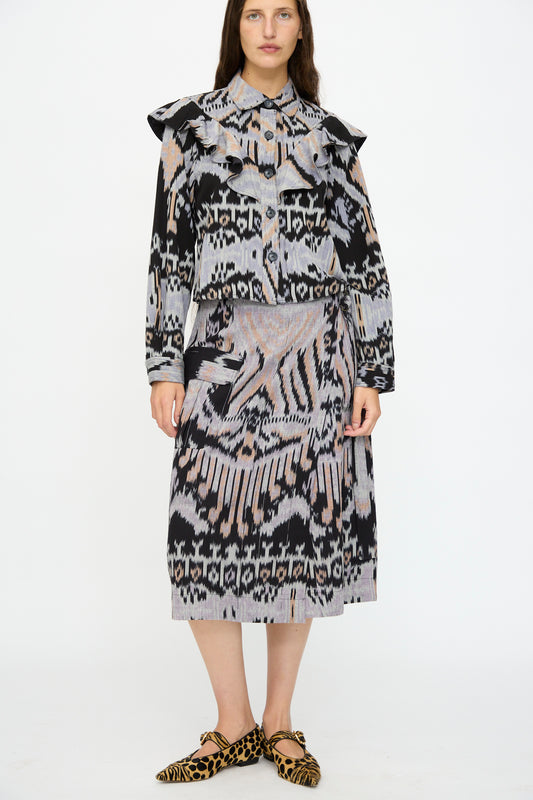 A woman wears a patterned blouse, the Ulla Johnson Mila Pencil Skirt in Tigereye, and leopard-print pointed flats against a plain white background.