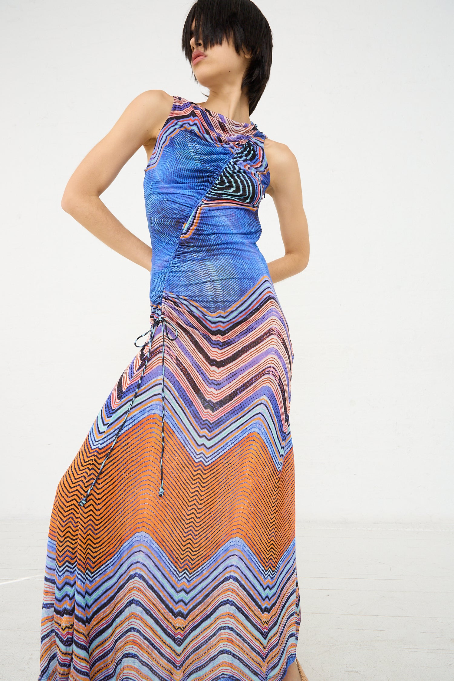 Woman posing in a sleeveless, multicolored zigzag patterned Ulla Johnson Natalia Dress in Neptune against a white background.