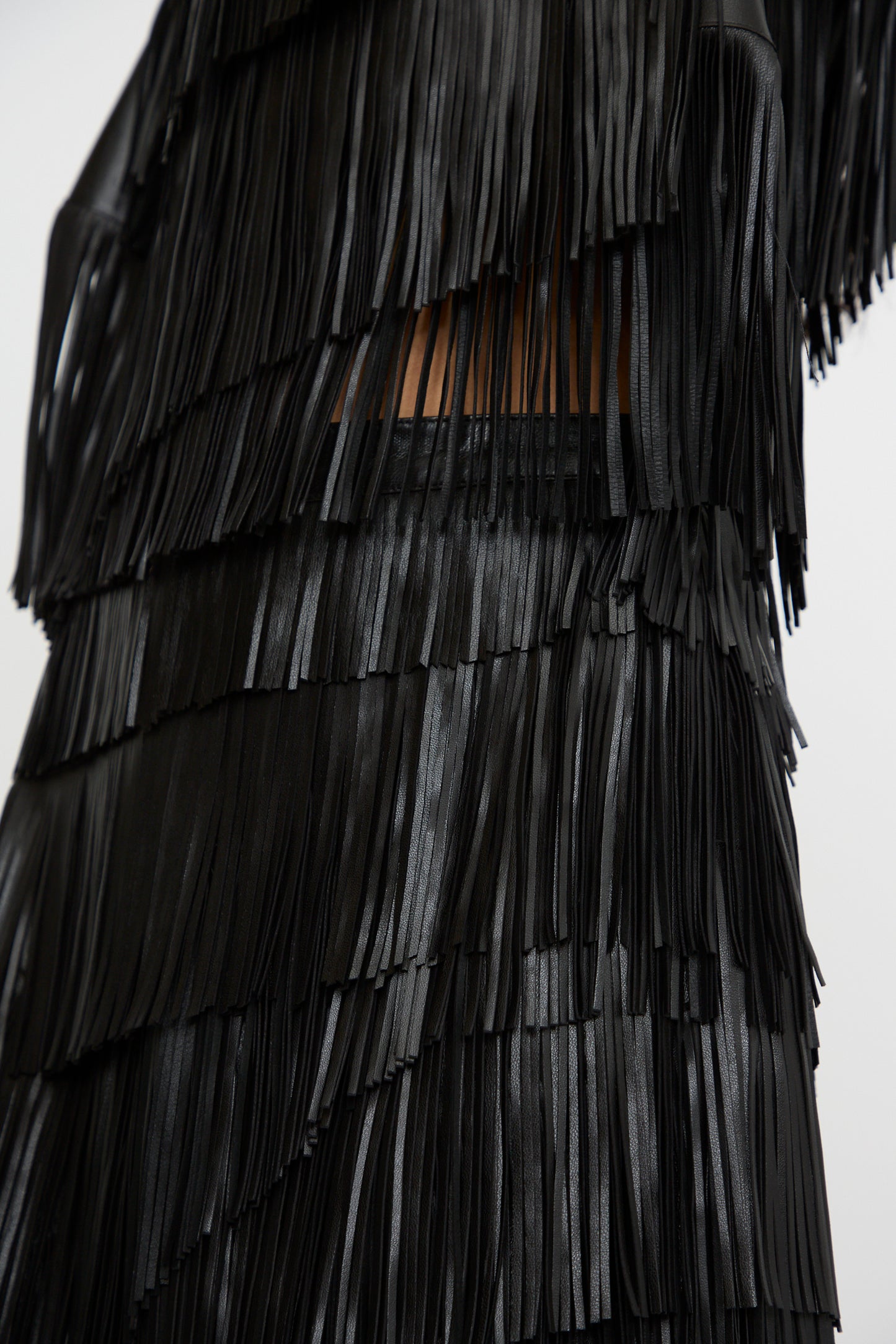 Close-up of the Therese Skirt in Noir by Ulla Johnson, featuring layered fringe crafted from lamb leather. 