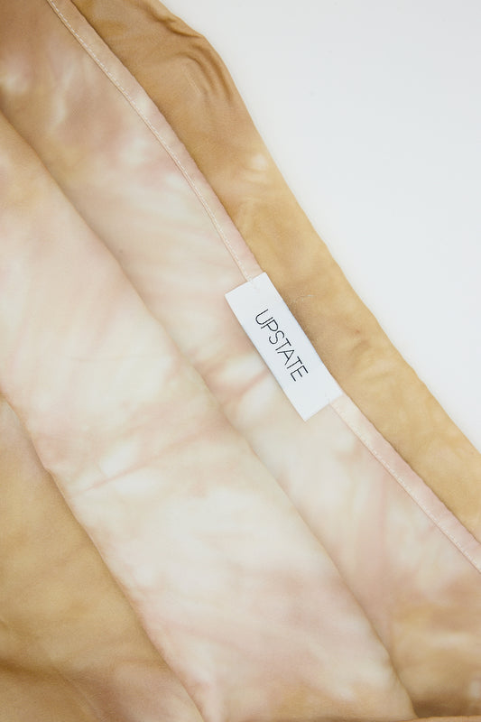 Silk Pillowcase in Sandstone with the brand "Upstate" on hand-dyed, marbled beige fabric.