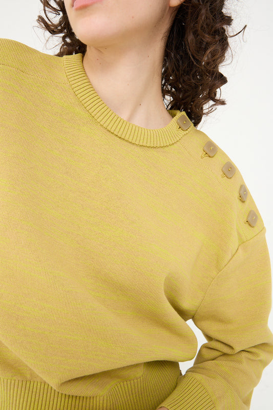 A close up of a woman's neck adorned with a Veronique Leroy Cotton Boxy Sweater in Curry.