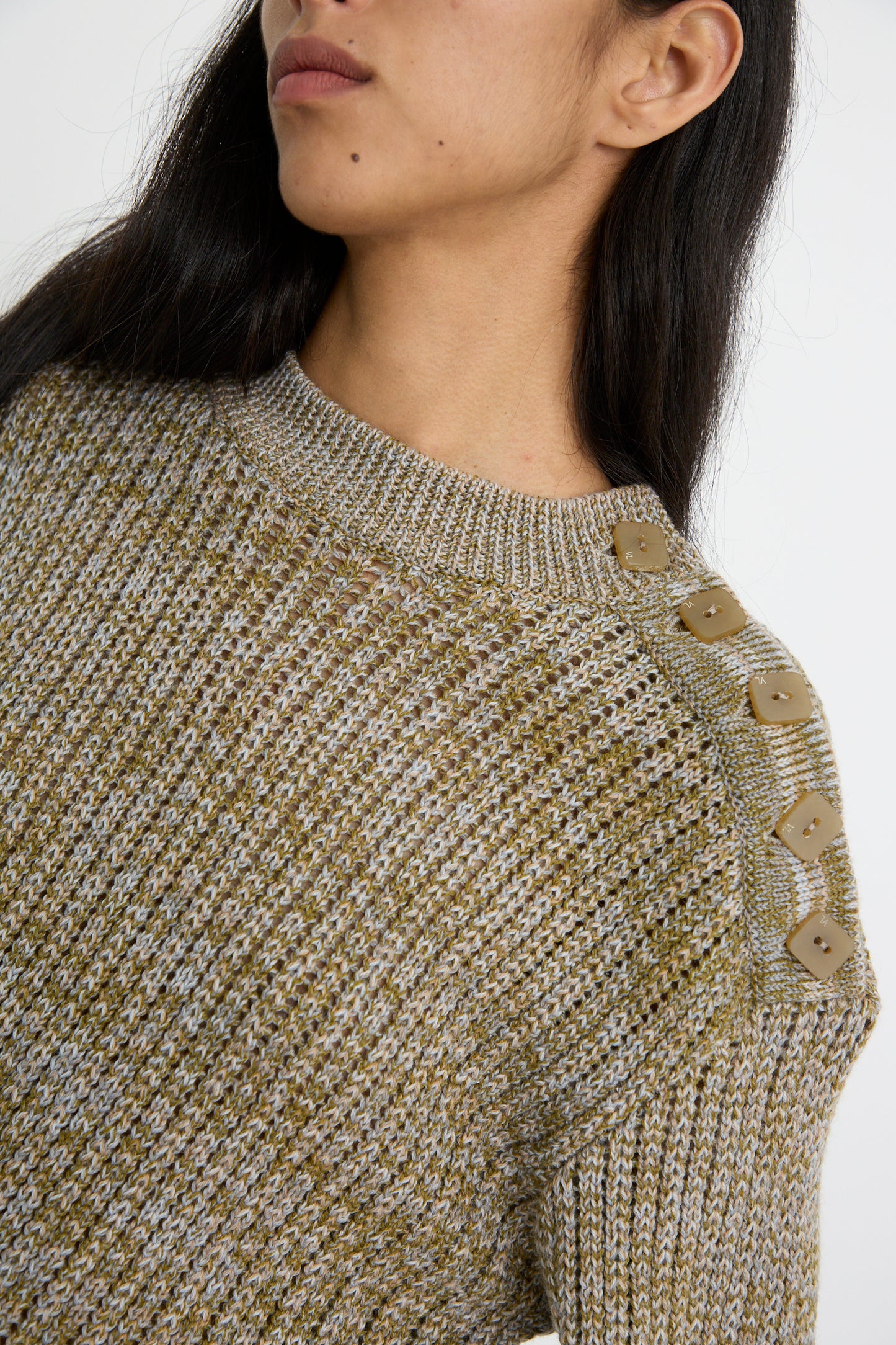 A close up of a person wearing the Button Shoulder Sweater in Meadown by Veronique Leroy, featuring a boxy fit and button details on the shoulder.