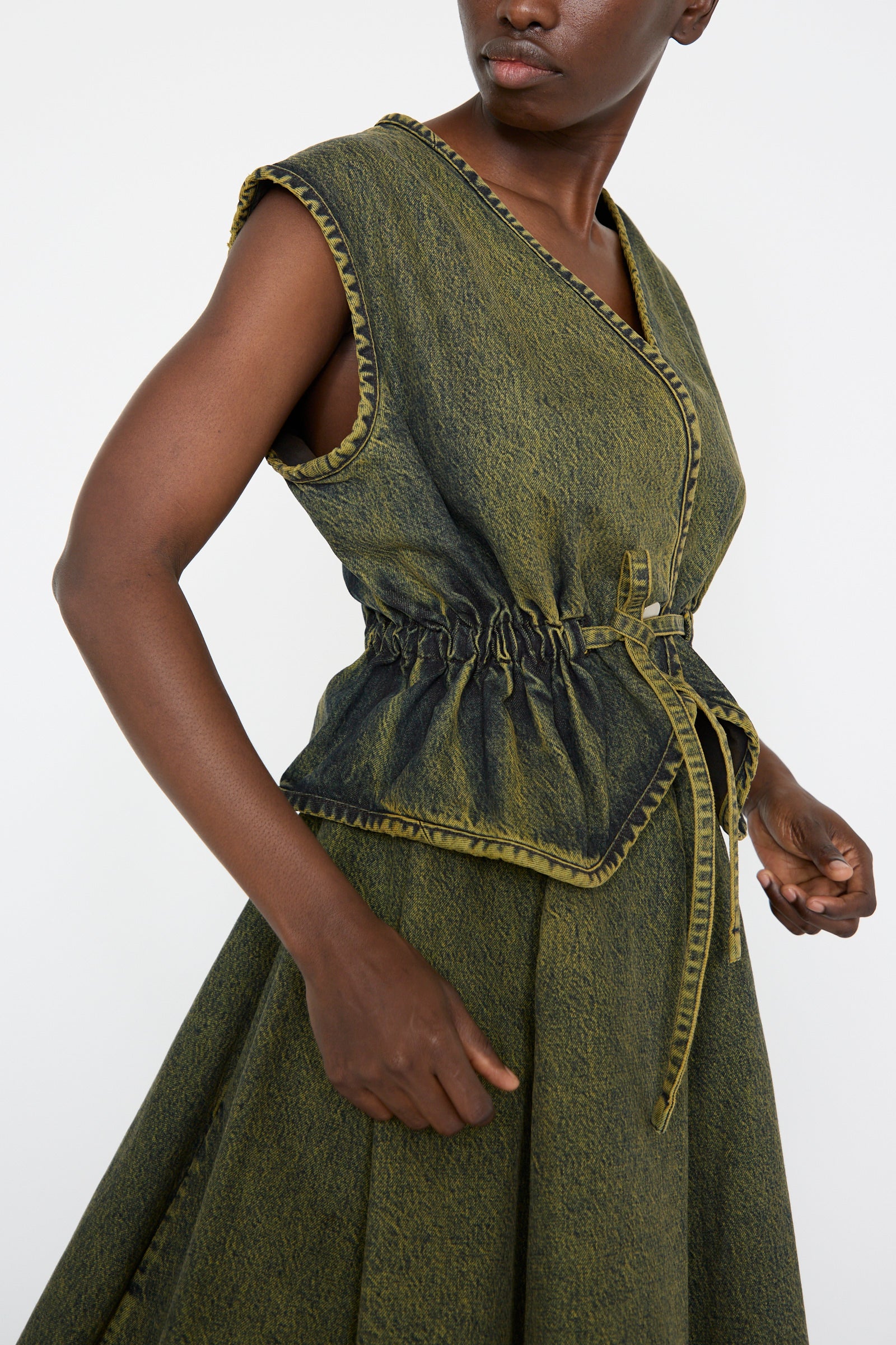 A person wearing a denim top and skirt in Cumin by Veronique Leroy, against a plain background.