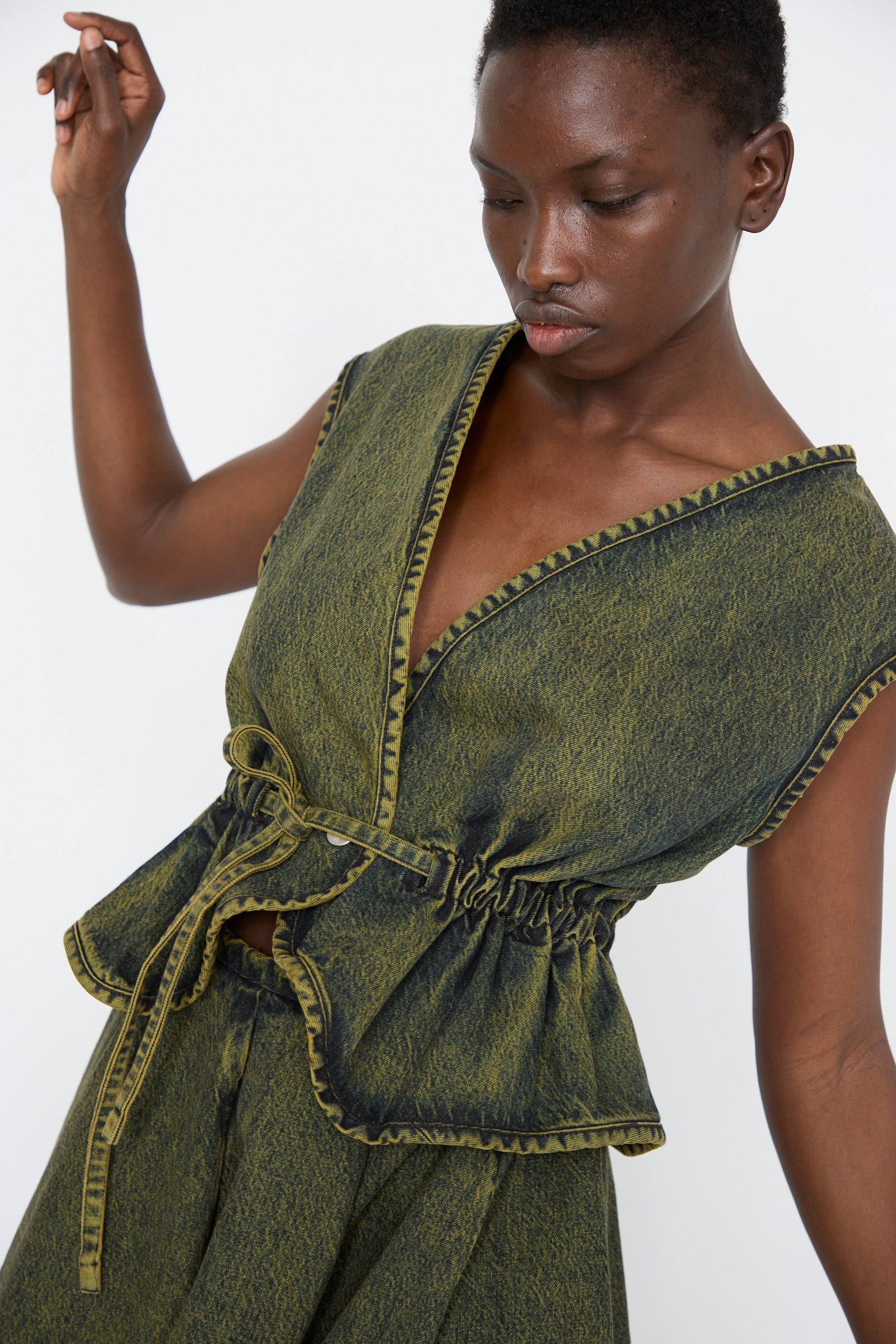 A cumin-toned denim vest by Veronique Leroy, an individual poses against a plain background.