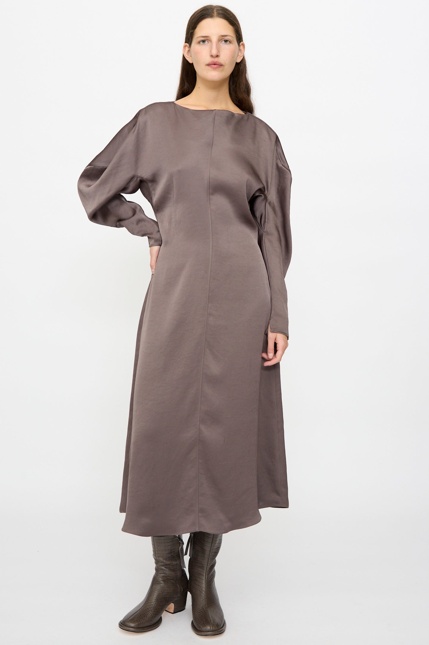 A woman stands against a plain background wearing the Veronique Leroy Dress with Scarf in Wood, styled with dark brown heeled boots.