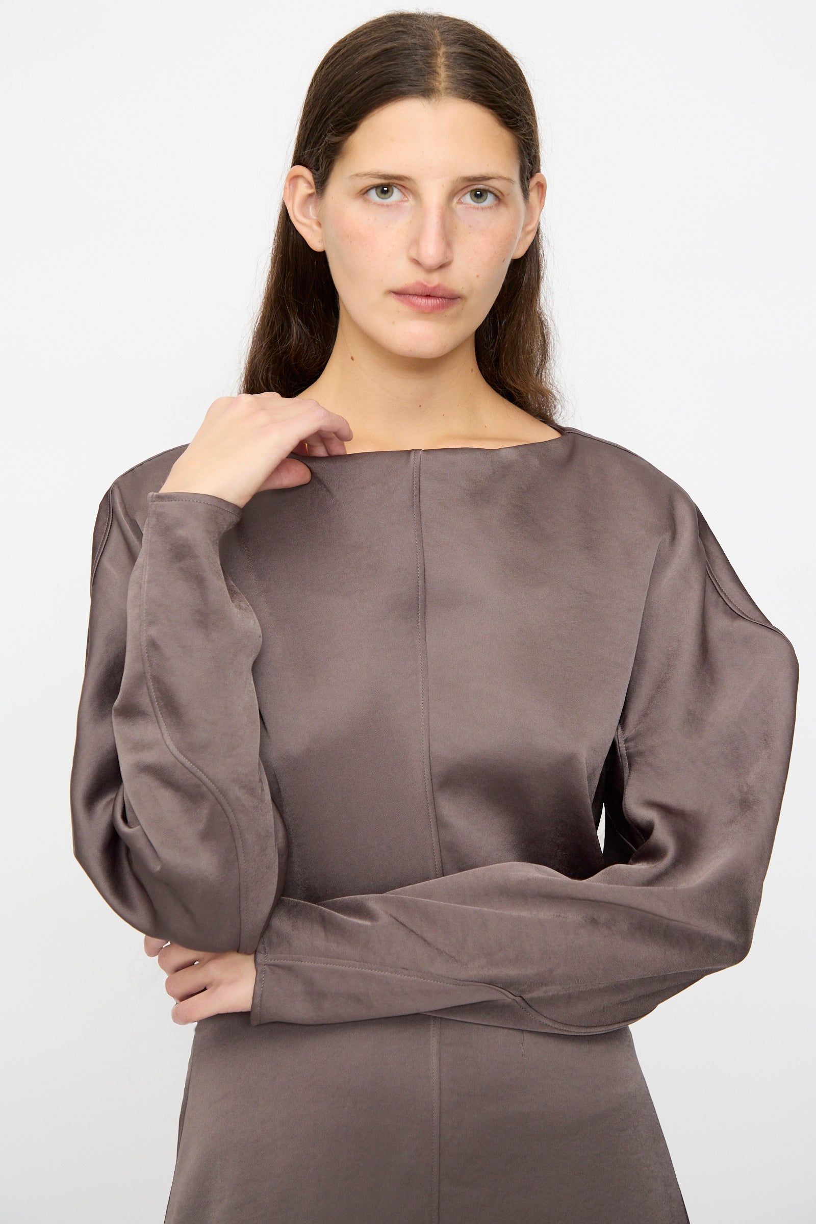 A woman with long brown hair wears the Veronique Leroy Dress with Scarf in Wood, featuring a fitted waist, standing against a white background and looking at the camera with a neutral expression.