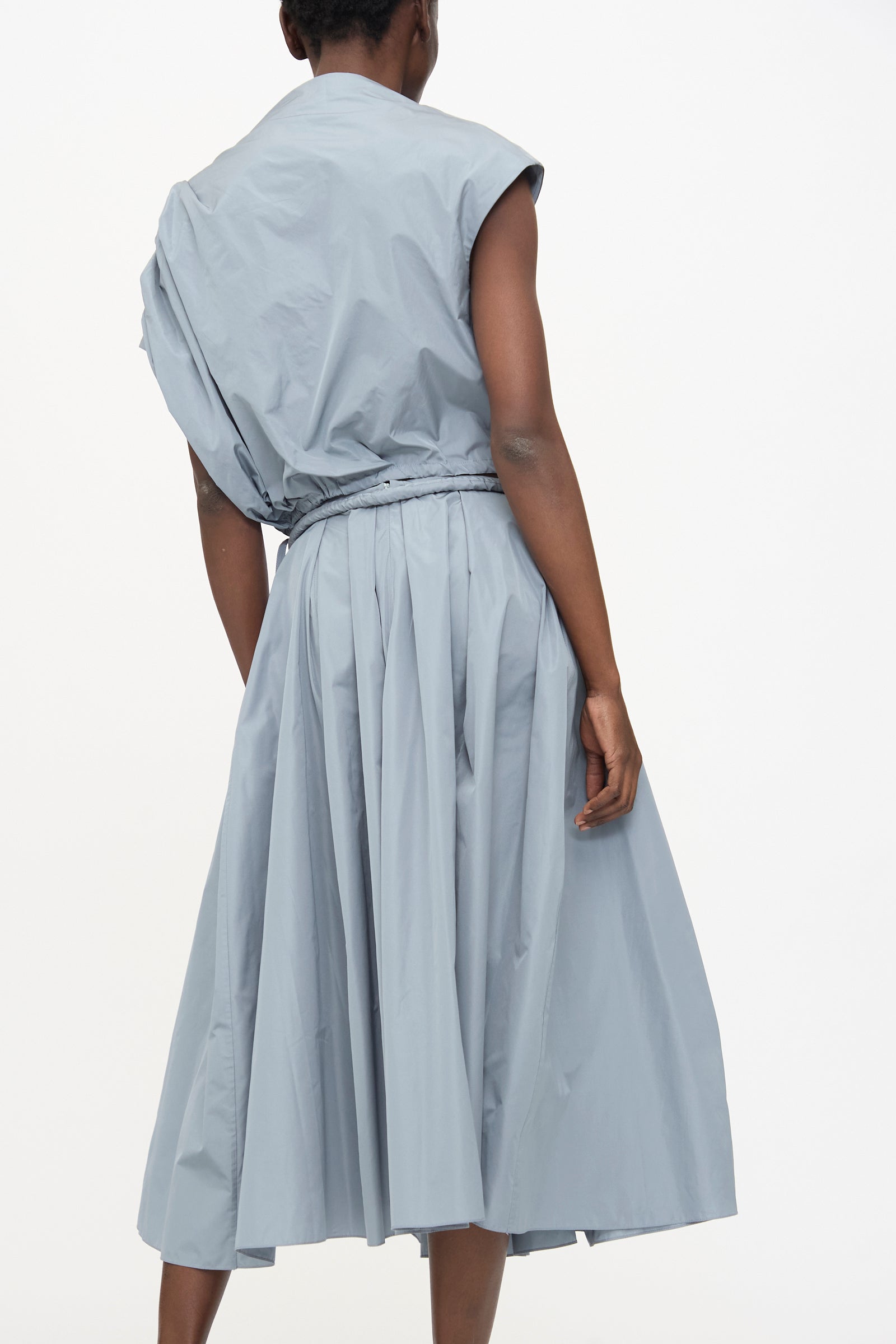 Model shown from behind wears the Veronique Leroy Taffeta Skirt in Storm, a light gray A-line midi skirt with an adjustable rope belt, against a plain white background.