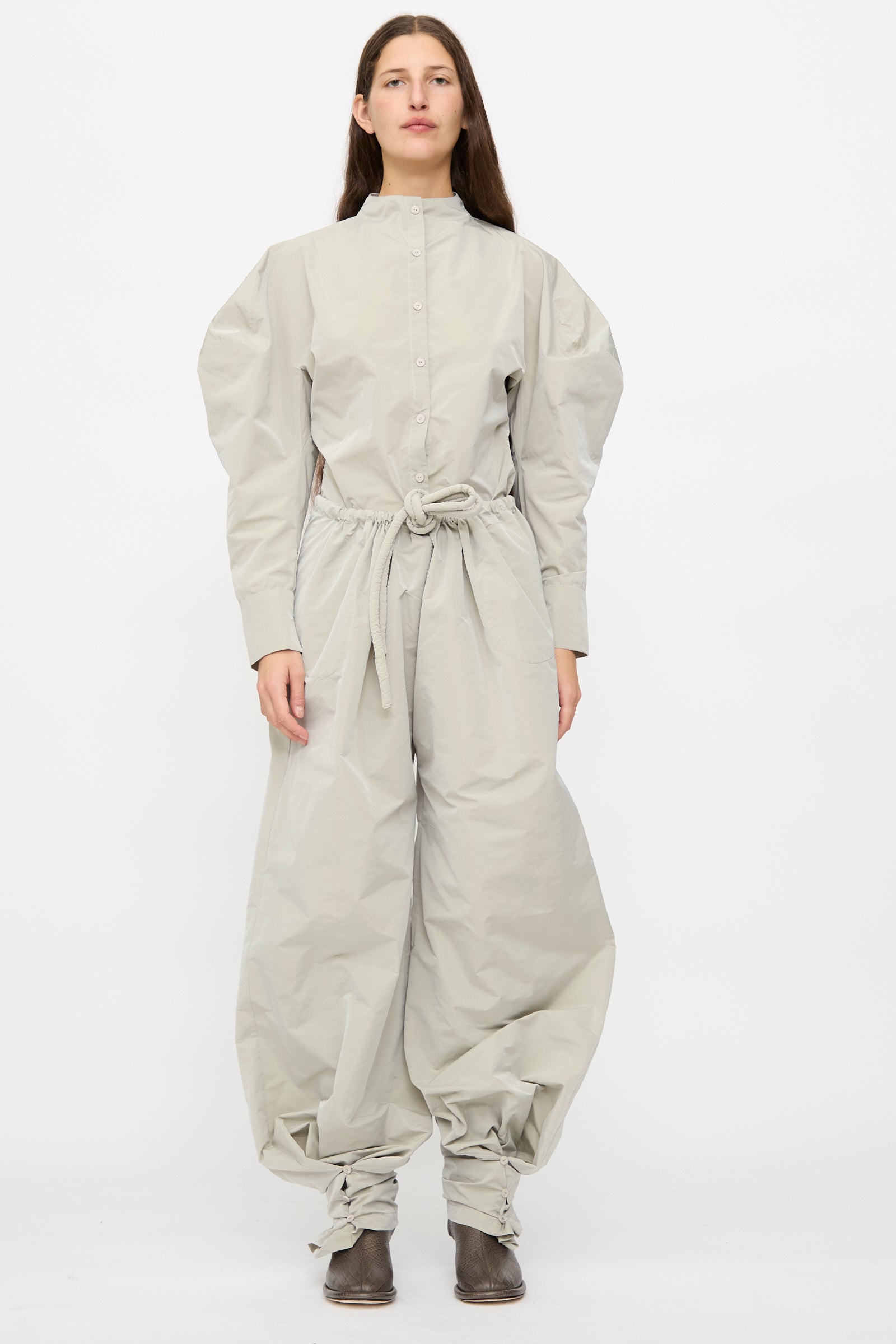 Person wearing Veronique Leroy's Tie Pants in Sage—loose-fitting, lightweight pants with a high waist and drawstring ankles—standing against a plain white background.